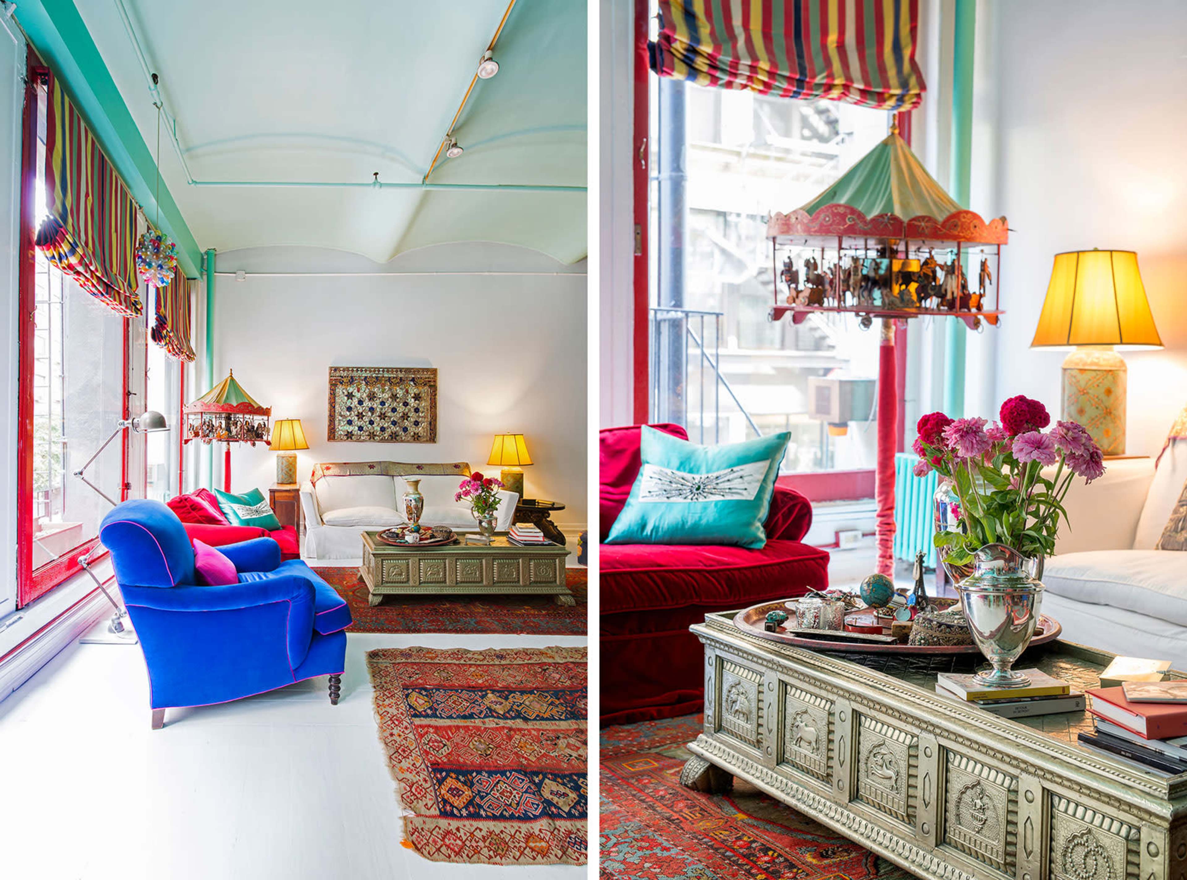 The image shows a brightly colored living space featuring a mix of furniture styles, decorative light fixtures, and a variety of textiles, with vibrant cushions and floral arrangements on a coffee table.