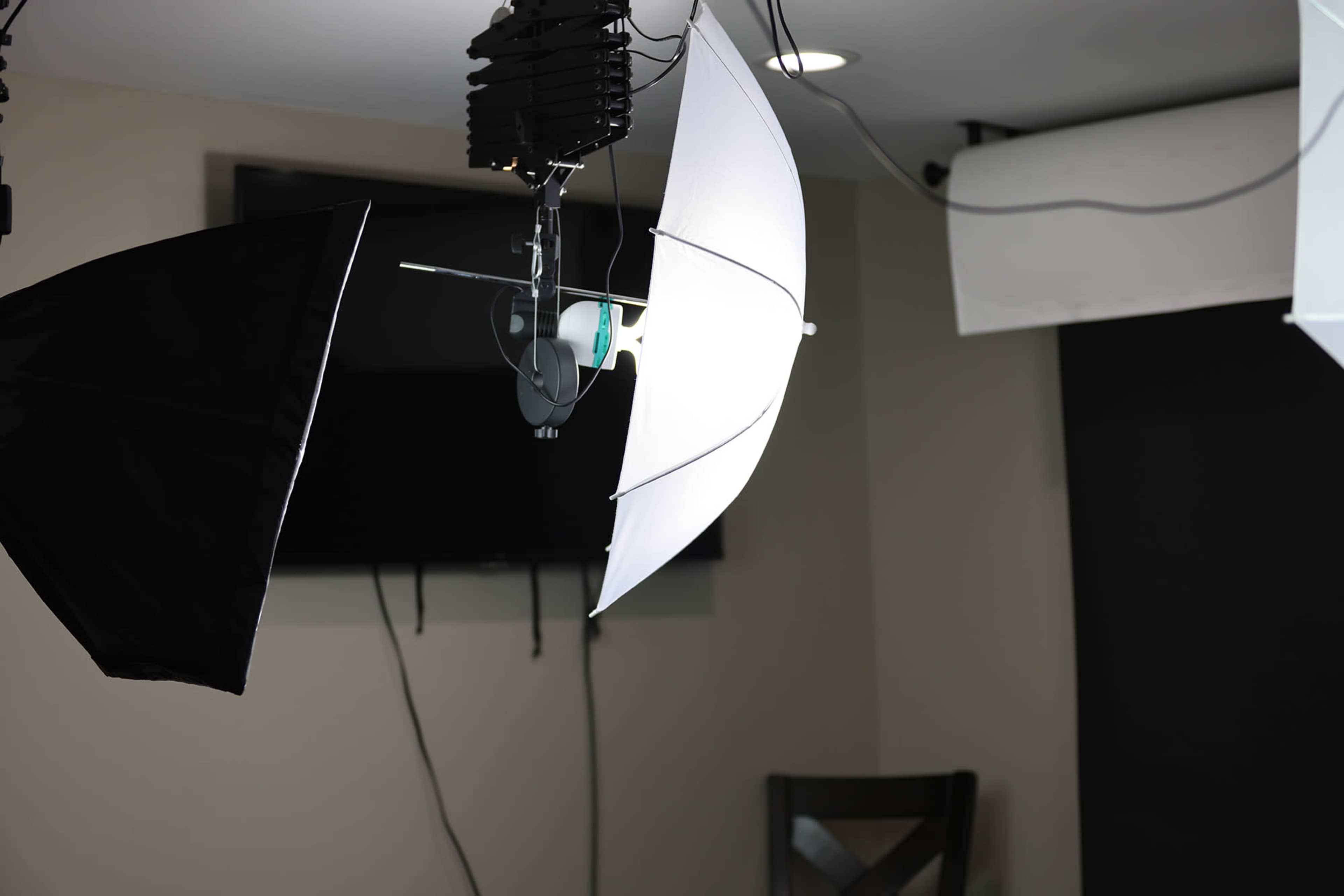 A photography setup with several light sources, including softbox lights and a black backdrop, in a studio environment.