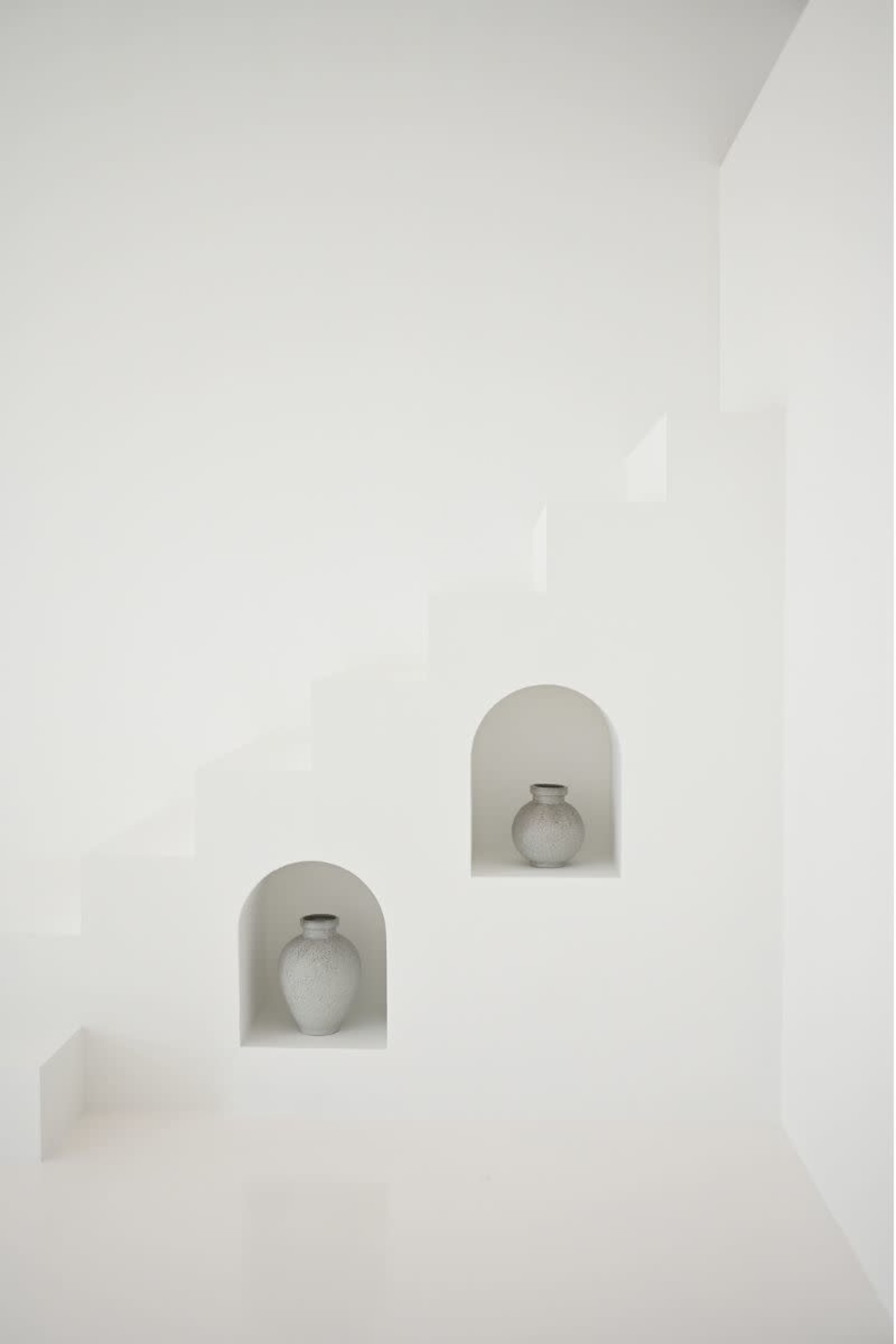 A minimalist staircase with two alcoves containing gray vases is set against a white wall.
