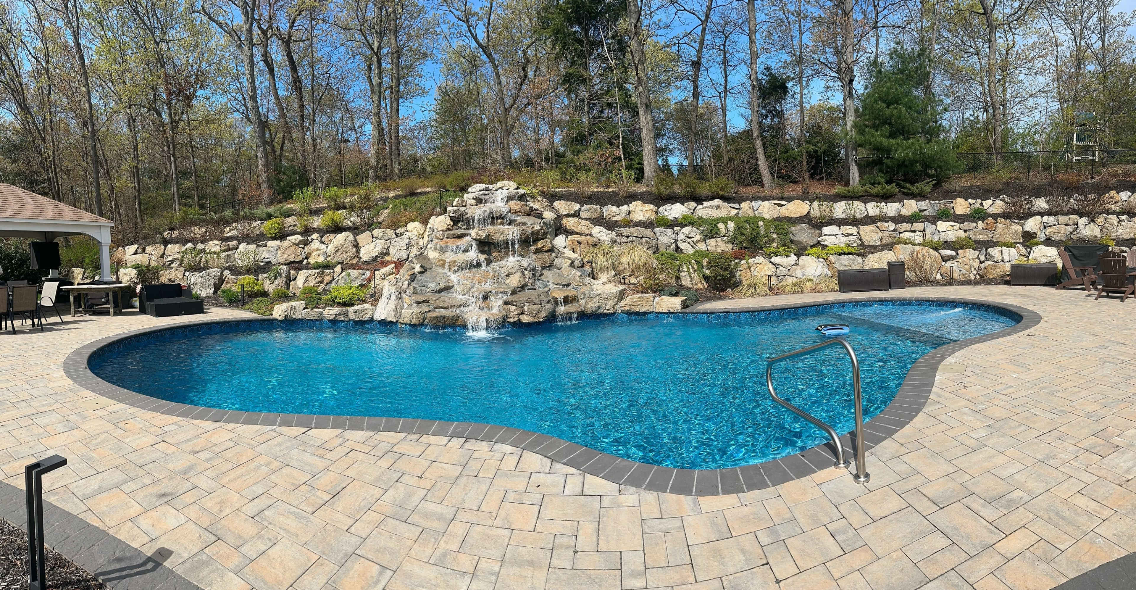 Resort style backyard with pool, pavilion, surround sound speakers and grills Image in Huntington, Melville, NY