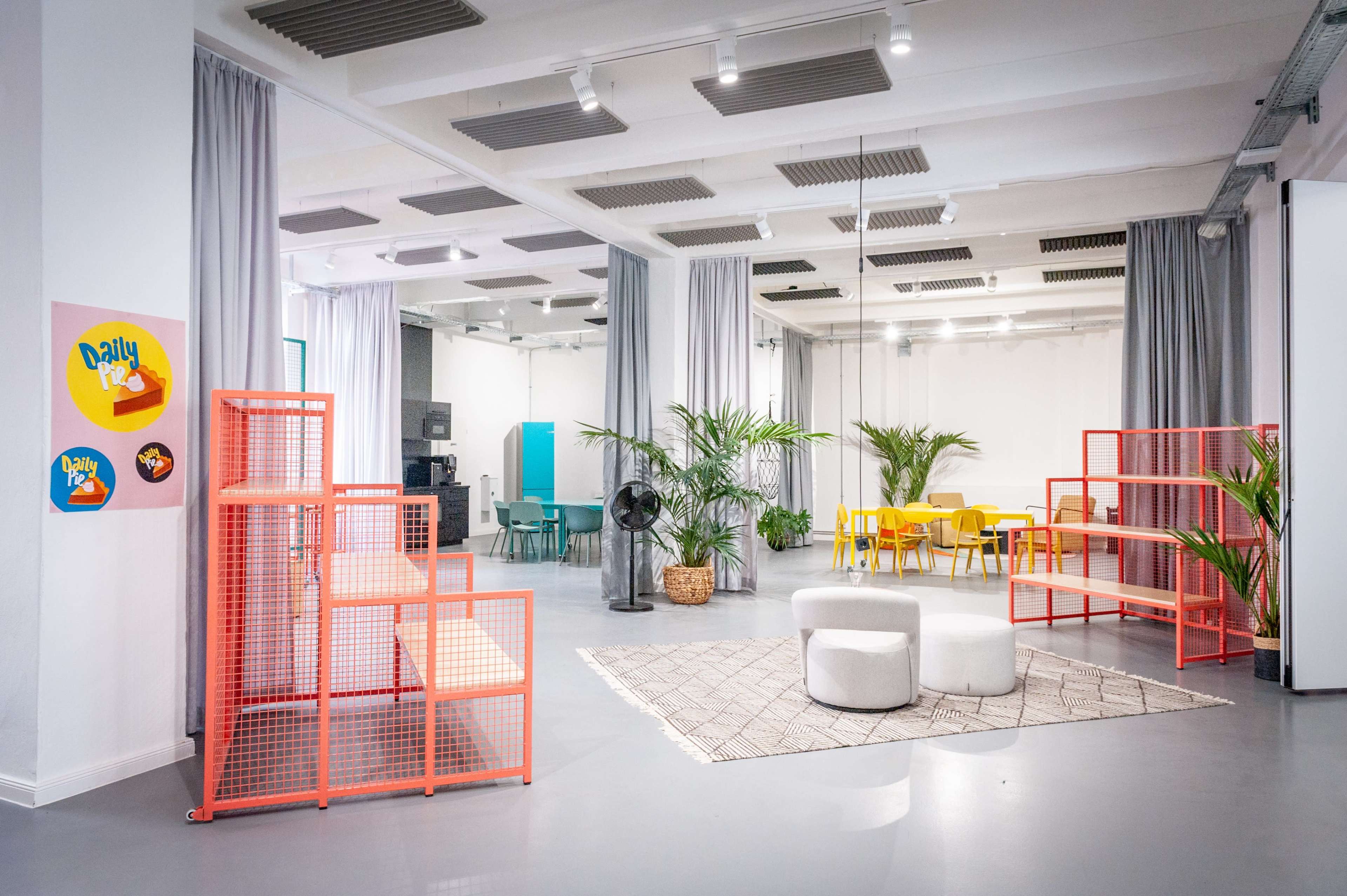 A modern open office space featuring colorful furniture, plants, and distinctive decor elements.