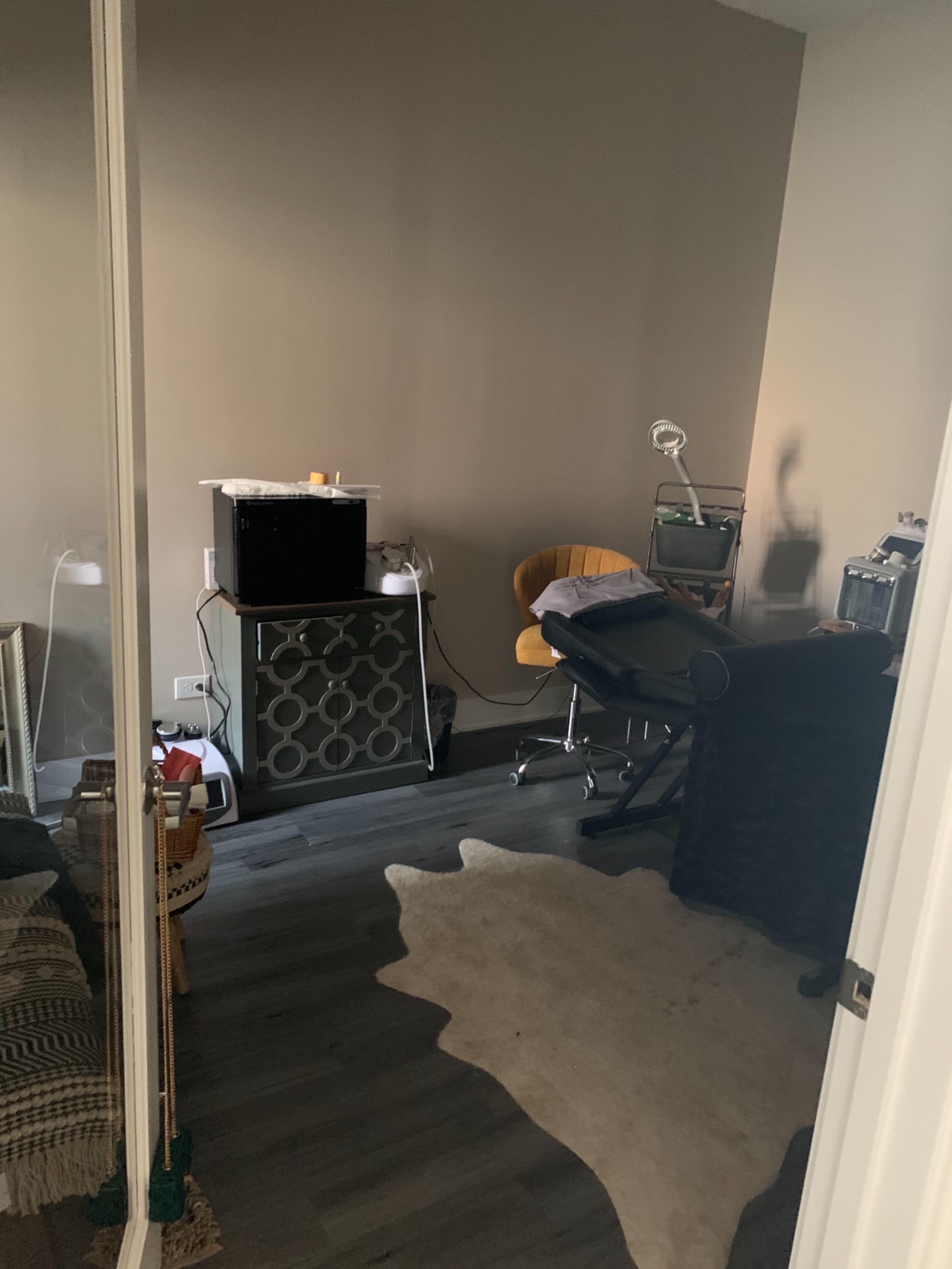 A small room with a chair, a portable table, and various equipment along the walls.