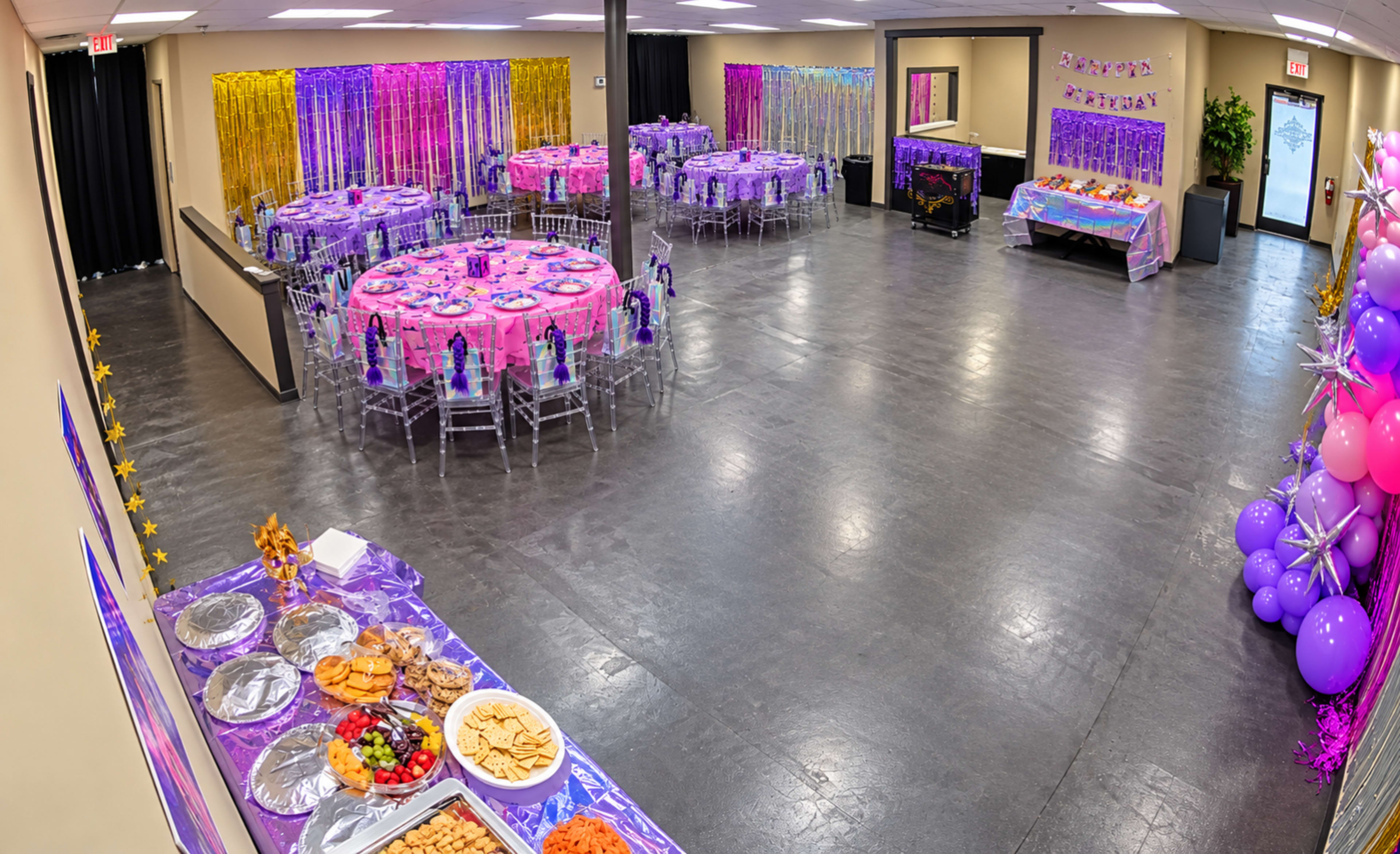 The image shows a large event space decorated with purple and pink table settings, featuring various food platters and multiple tables arranged for a celebration.