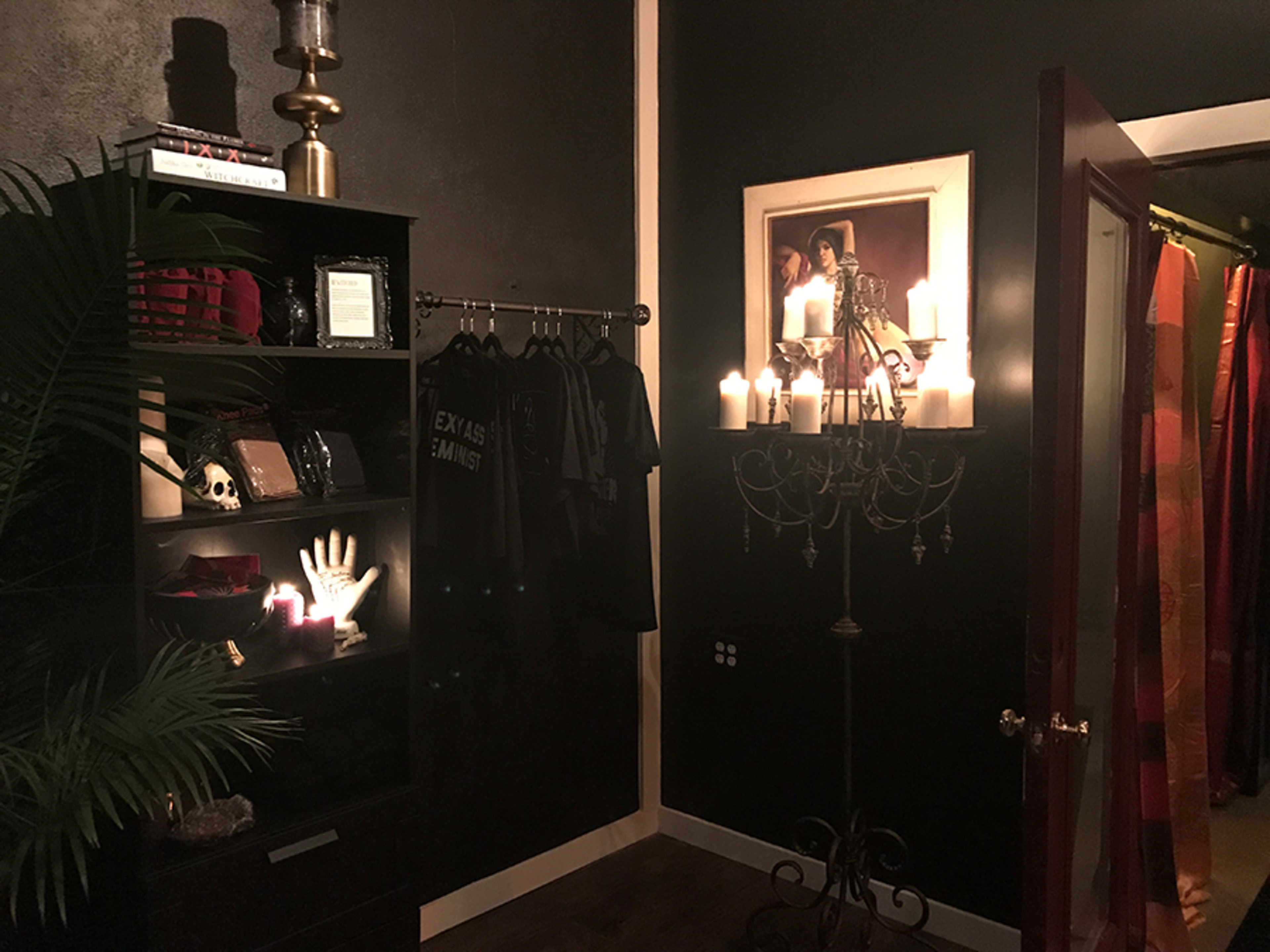 The scene features a dark room with a shelf displaying decorative items, a candelabra with lit candles, and a doorway leading to another area.