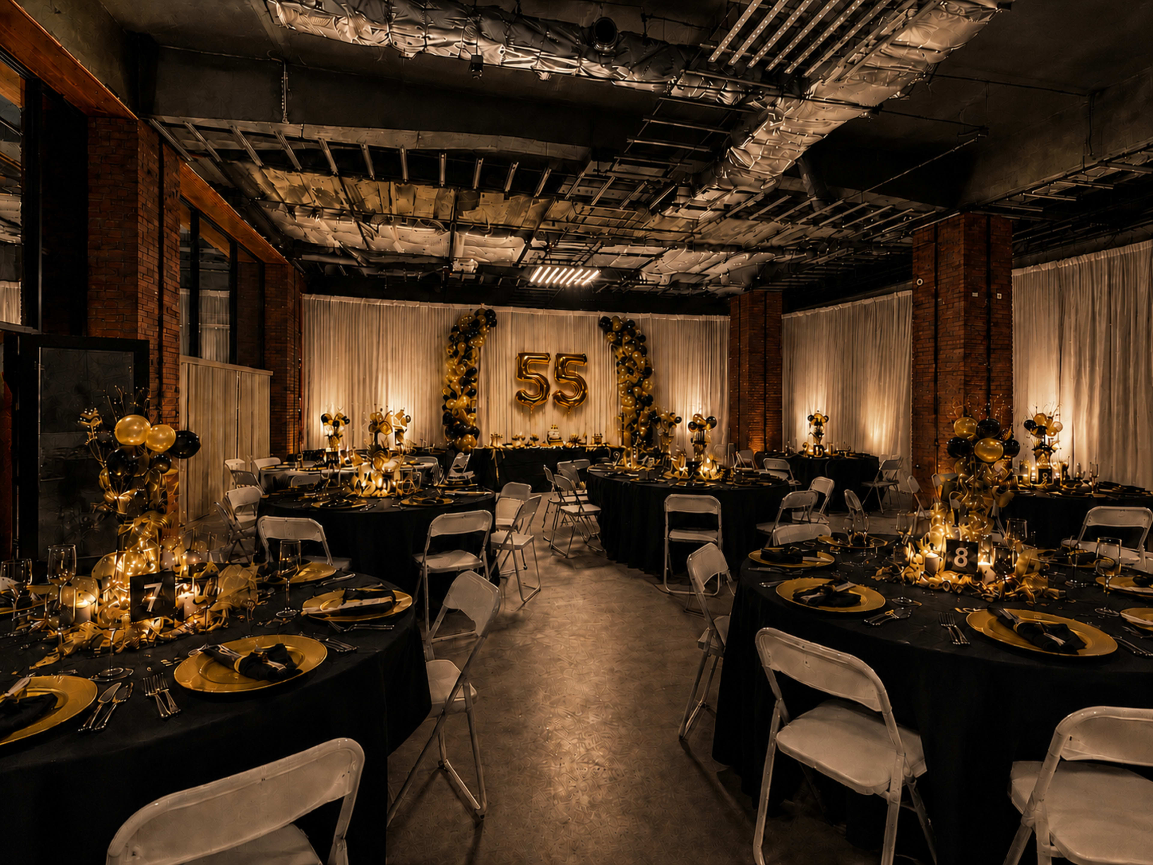 The image shows a dimly lit banquet hall set for a celebration, featuring round tables with black tablecloths, golden centerpieces, and a decorative backdrop displaying the number 55.