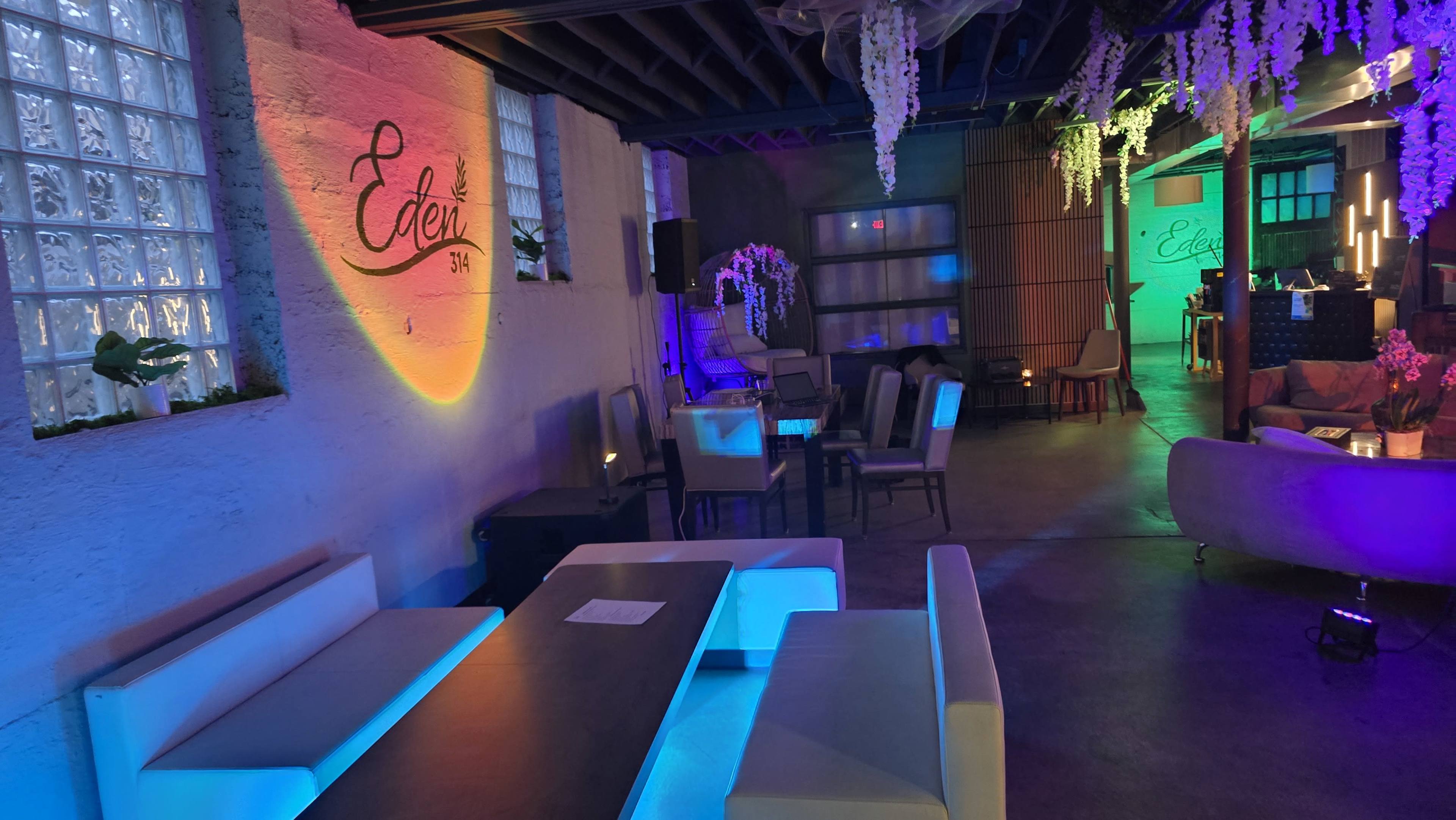 The interior of a venue named "Eden" features modern seating areas with colorful ambient lighting and decorative plants.