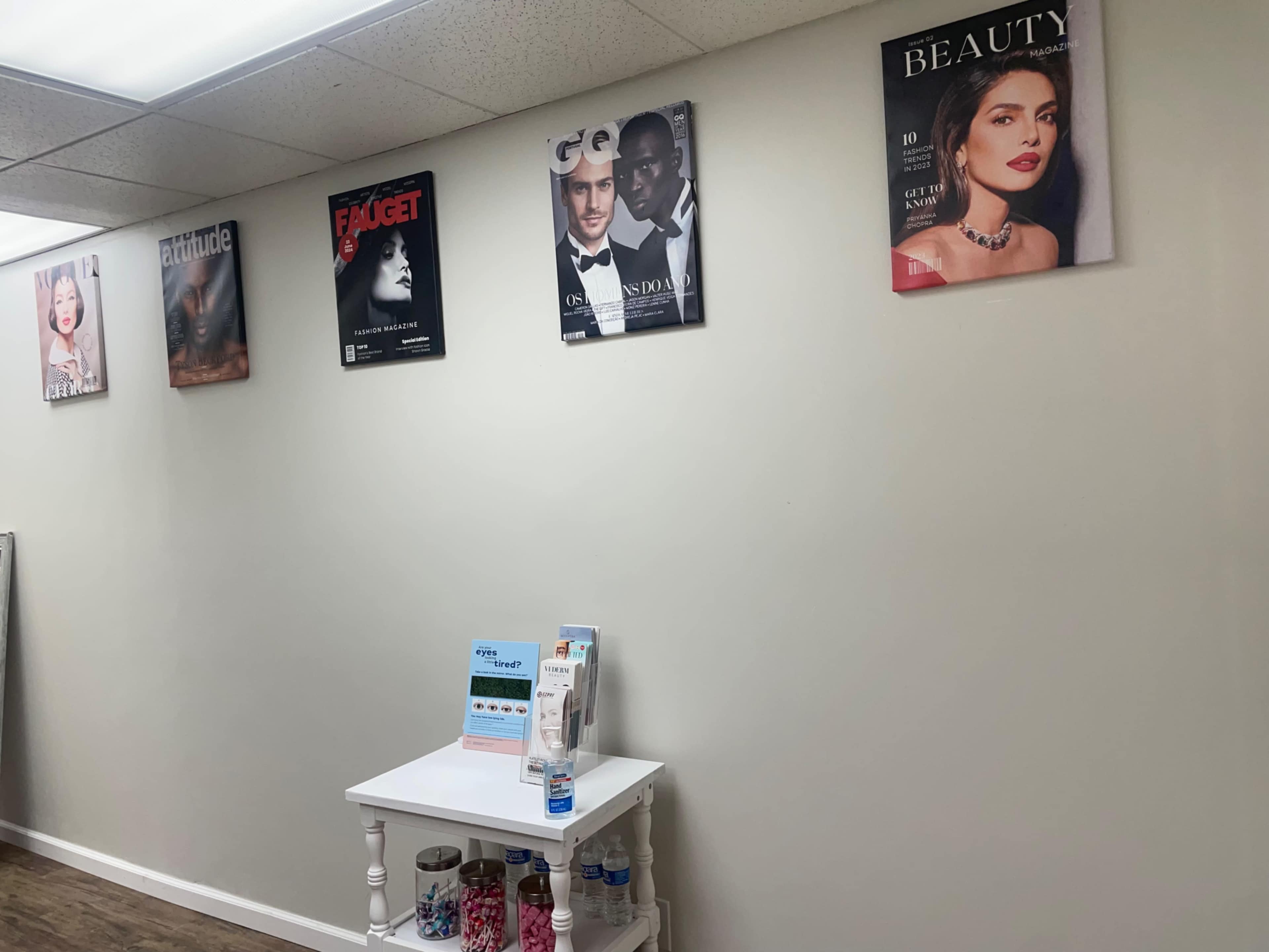 A wall in a waiting area decorated with magazine covers, along with a small table displaying promotional materials.