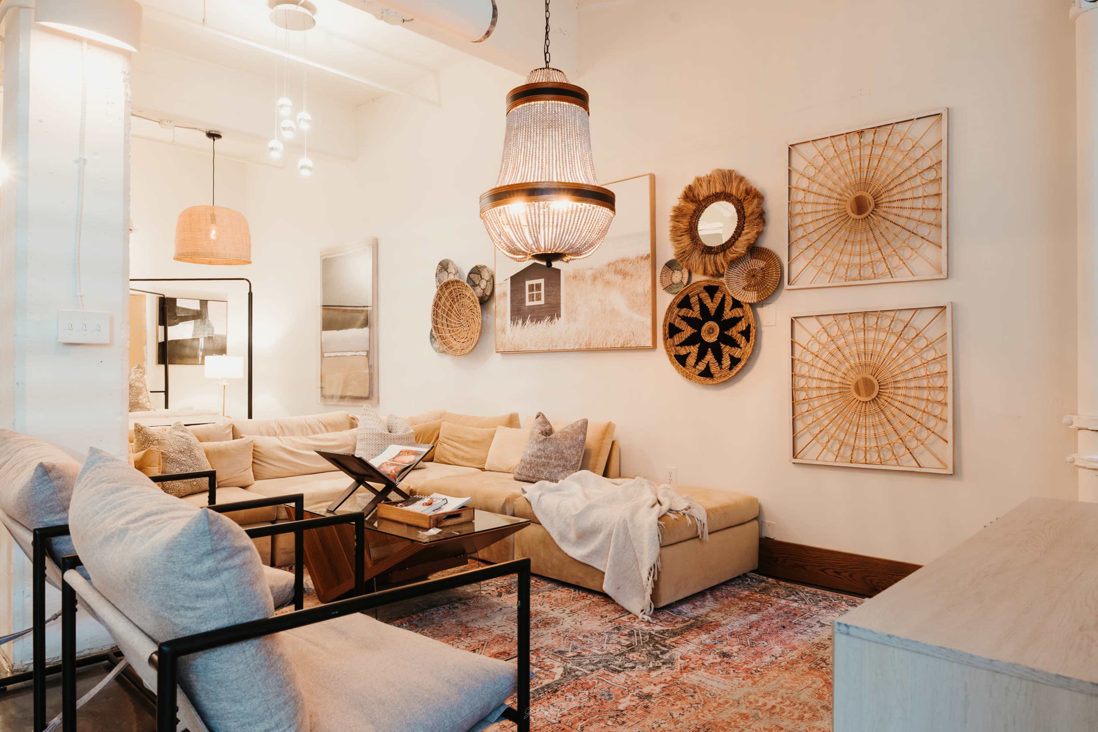 The scene features a modern living room with a large beige sectional sofa, decorative wall art, woven wall hangings, and various light fixtures.