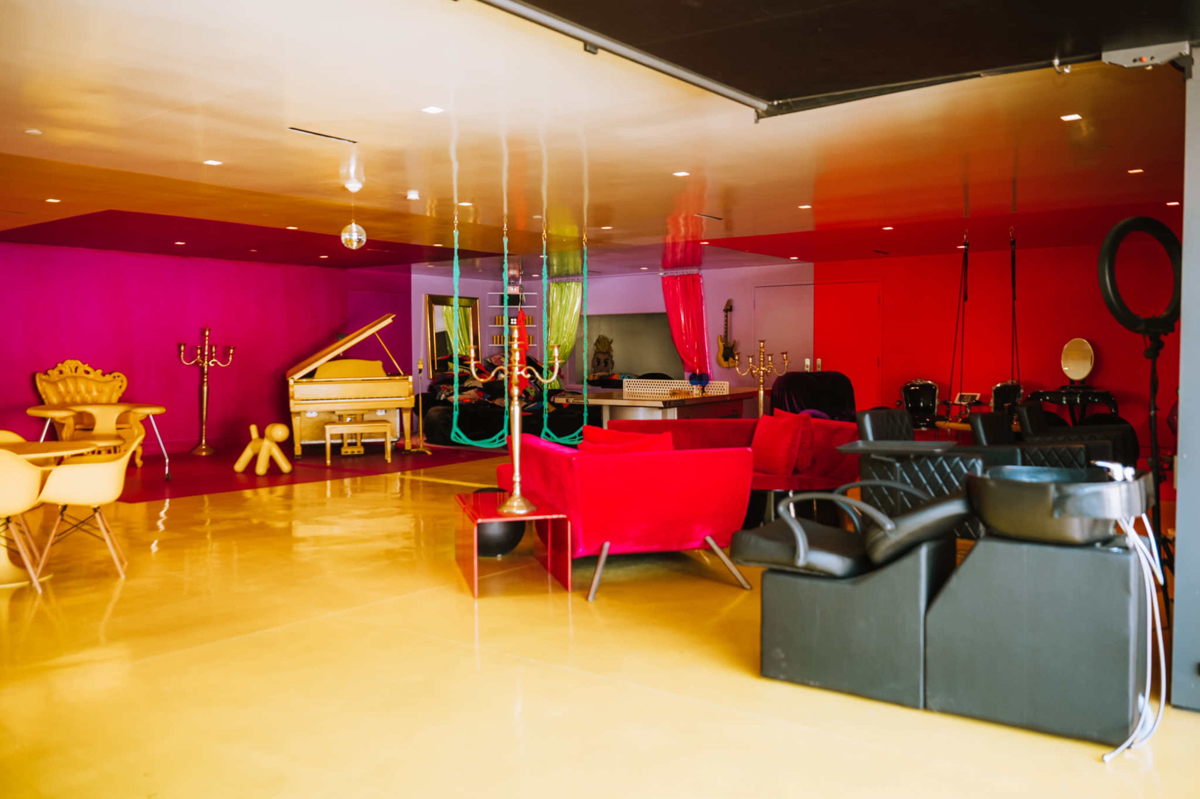 A vibrant interior space featuring a mix of colorful walls, varied seating options, and a piano.