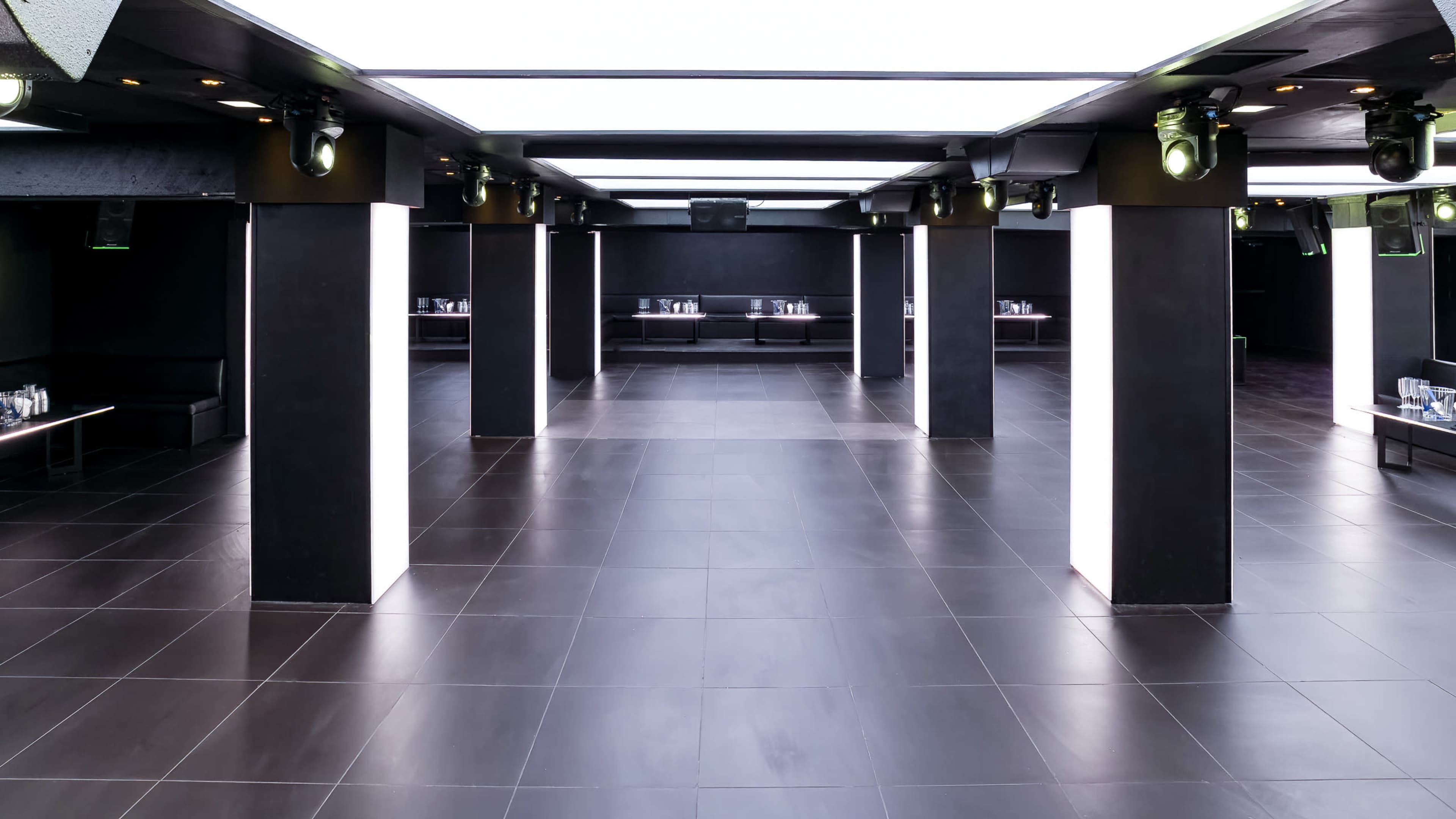 A spacious, modern interior with black pillars, sleek flooring, and a minimalistic design.