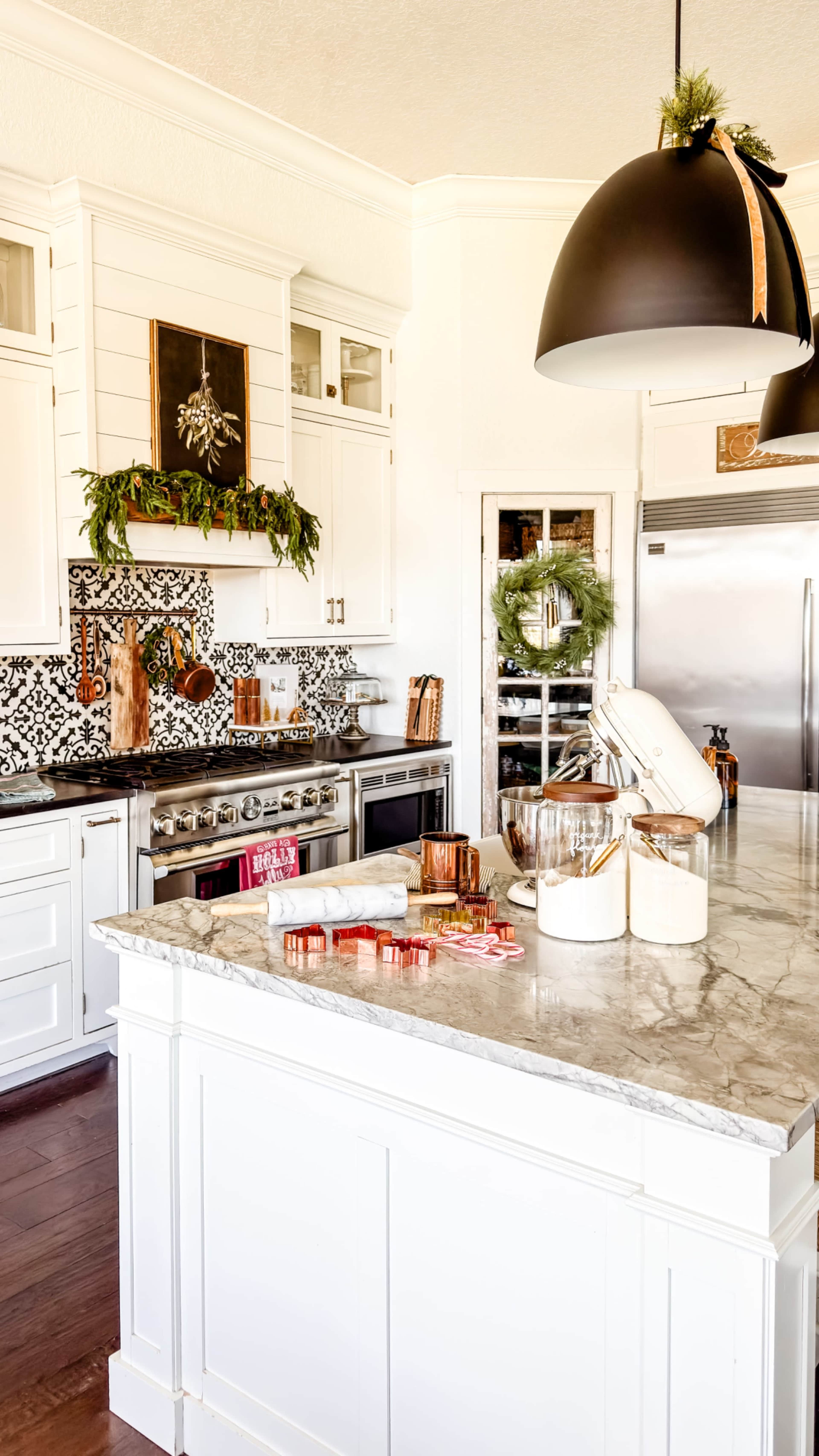 The image shows a modern kitchen with a marble countertop, white cabinets, and decorative wall tiles featuring a black and white pattern.