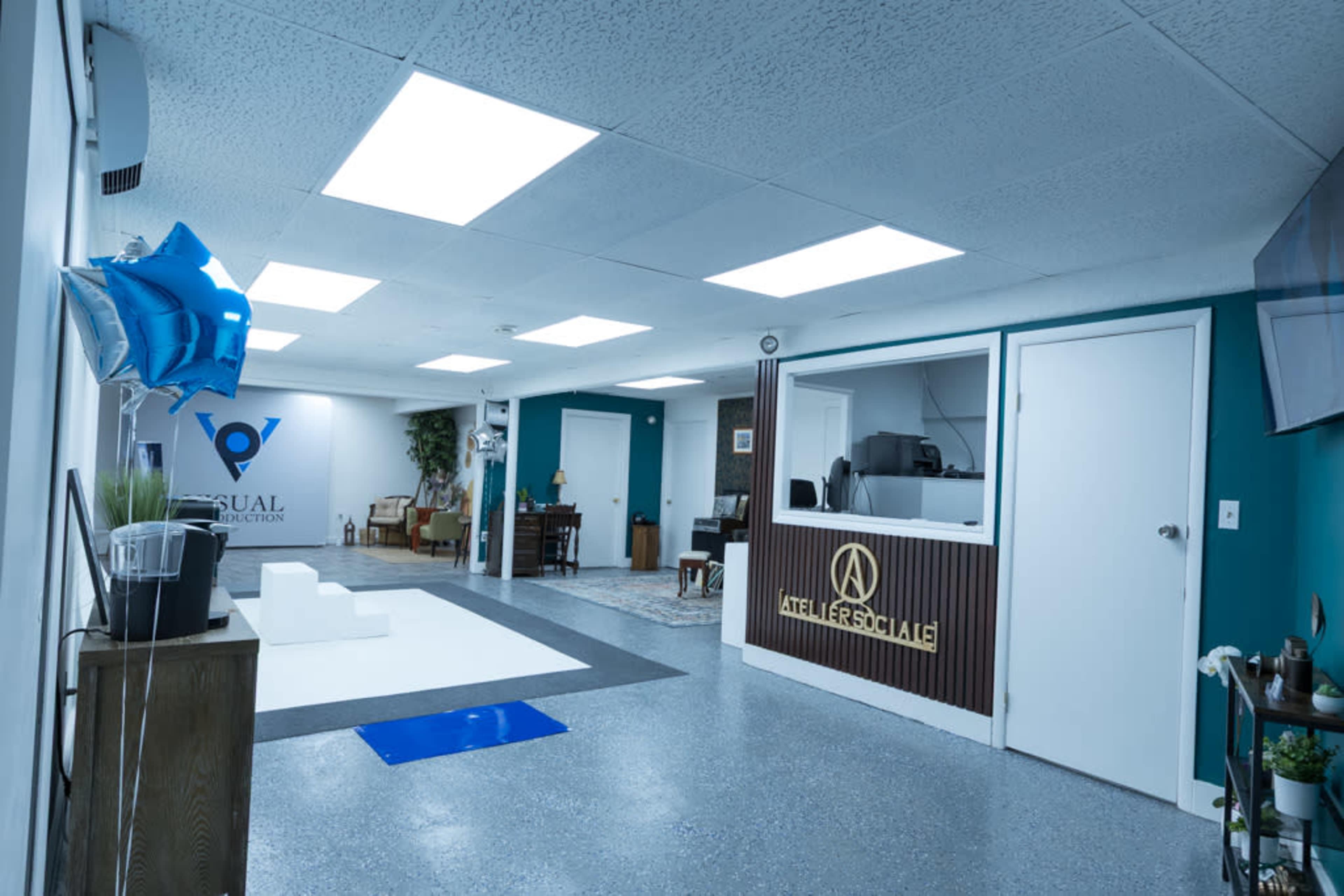 The image shows a brightly lit reception area of a business with a front desk, seating, and decorative elements.
