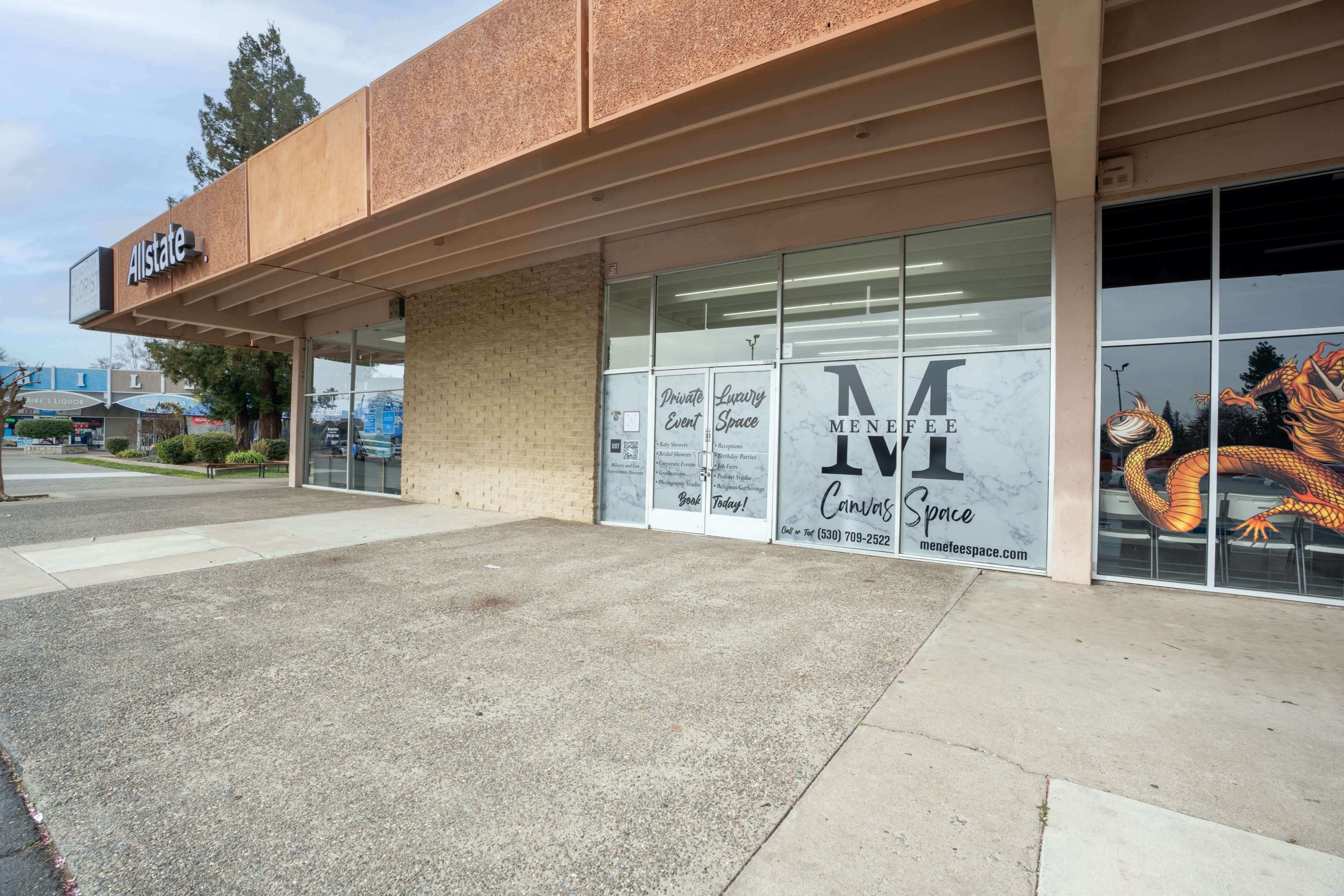 The exterior of a commercial building with an Allstate office and a window display for Menifee Currency Exchange.