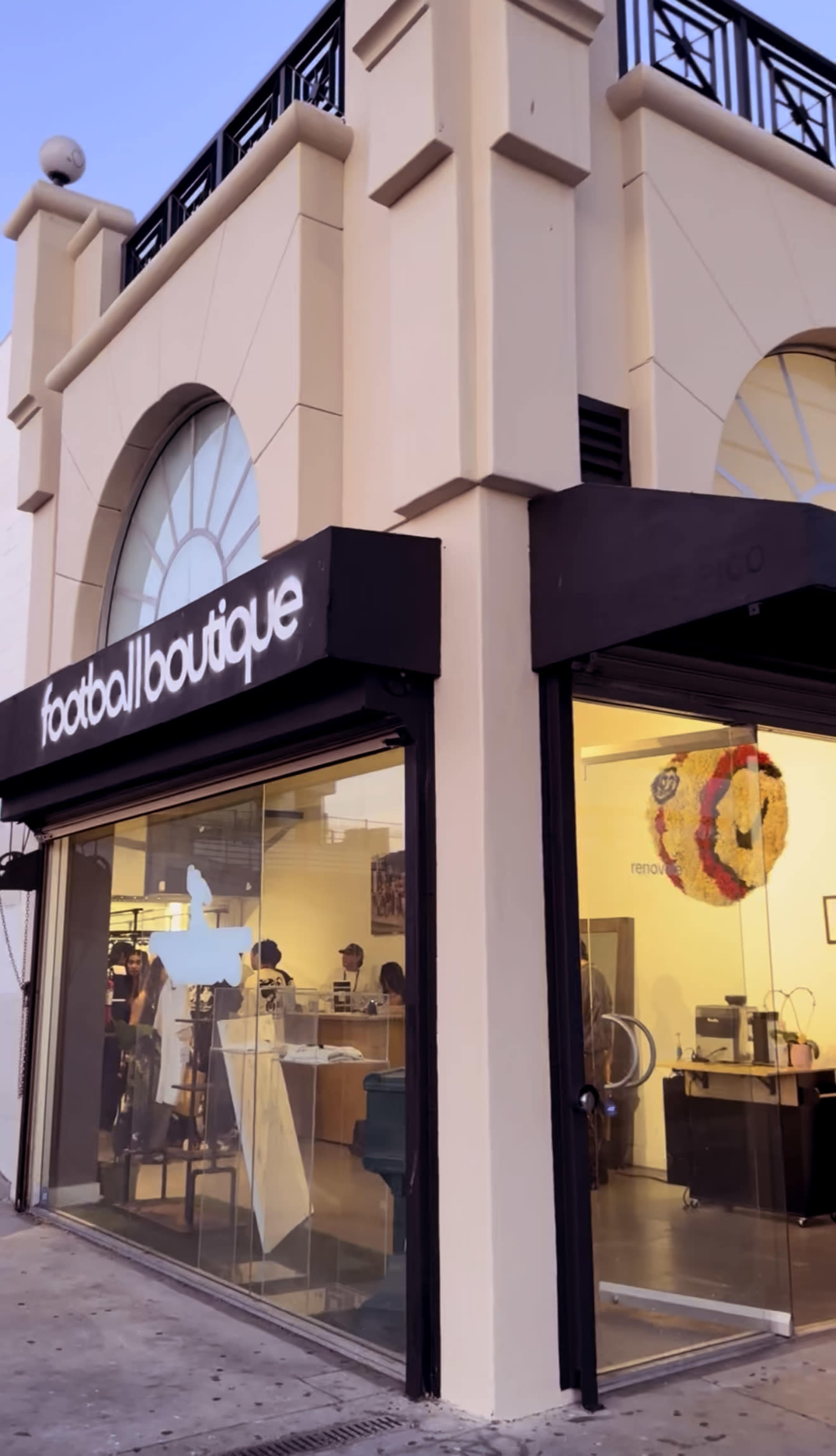 The image shows the exterior of a shop called "football boutique," featuring large glass windows and a decorative mural above the entrance.