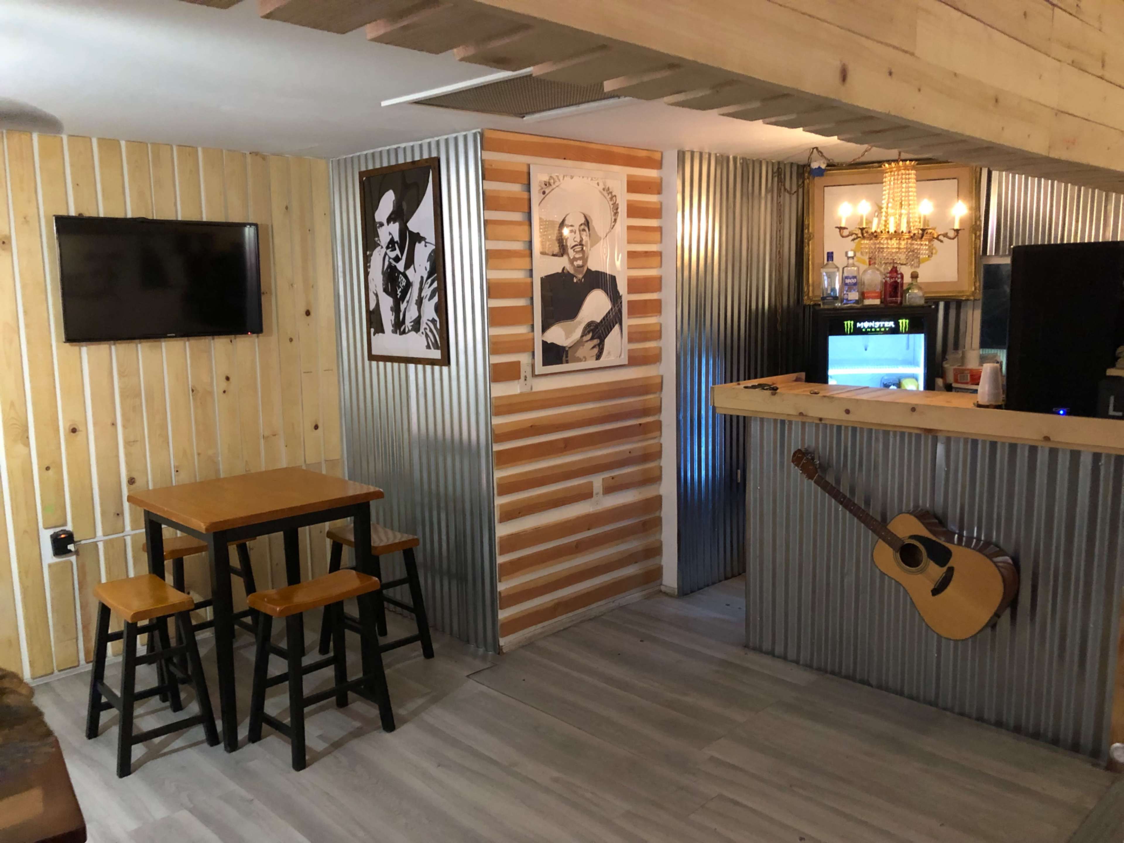 A rustic-style interior with a wooden table and chairs, metal accents, and wall decorations featuring music-themed artwork.