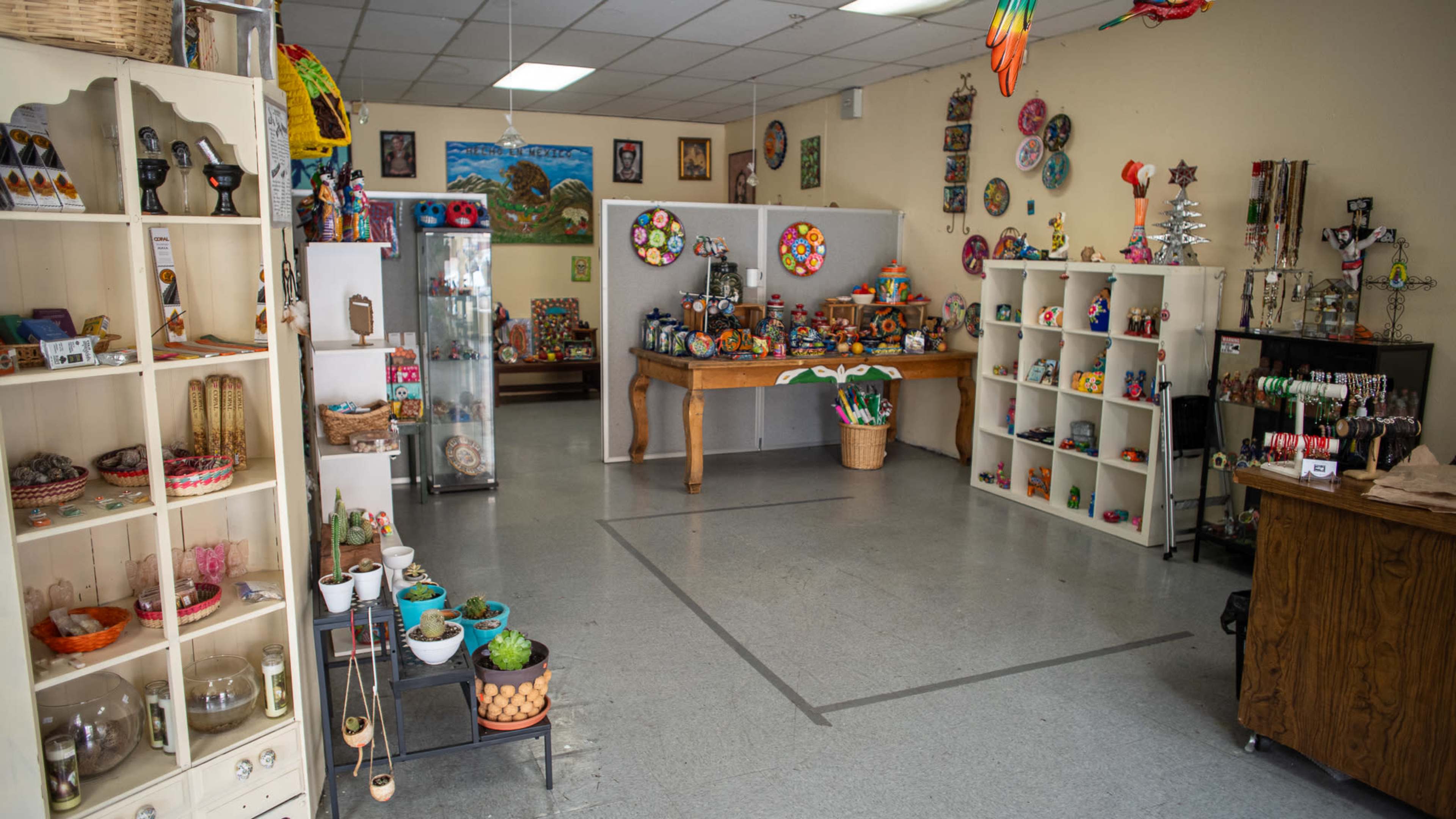 A brightly lit shop interior filled with various handcrafted items displayed on shelves and tables.