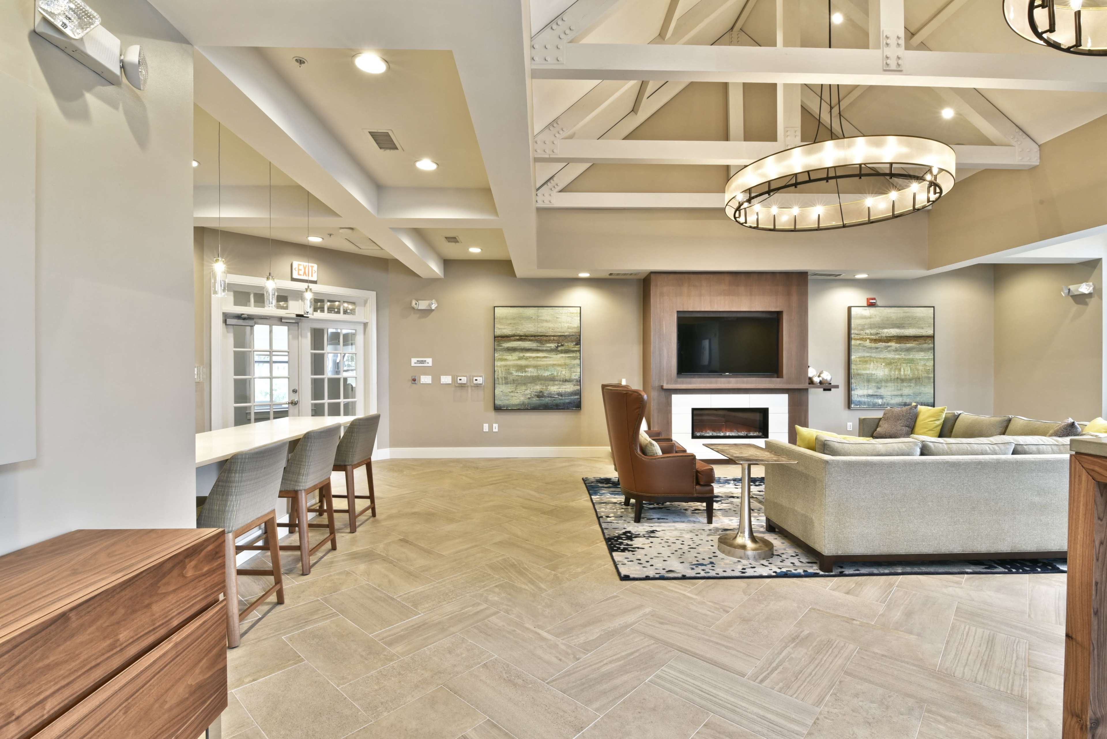 A modern indoor lounge area with a seating arrangement, a fireplace, and a bar counter.