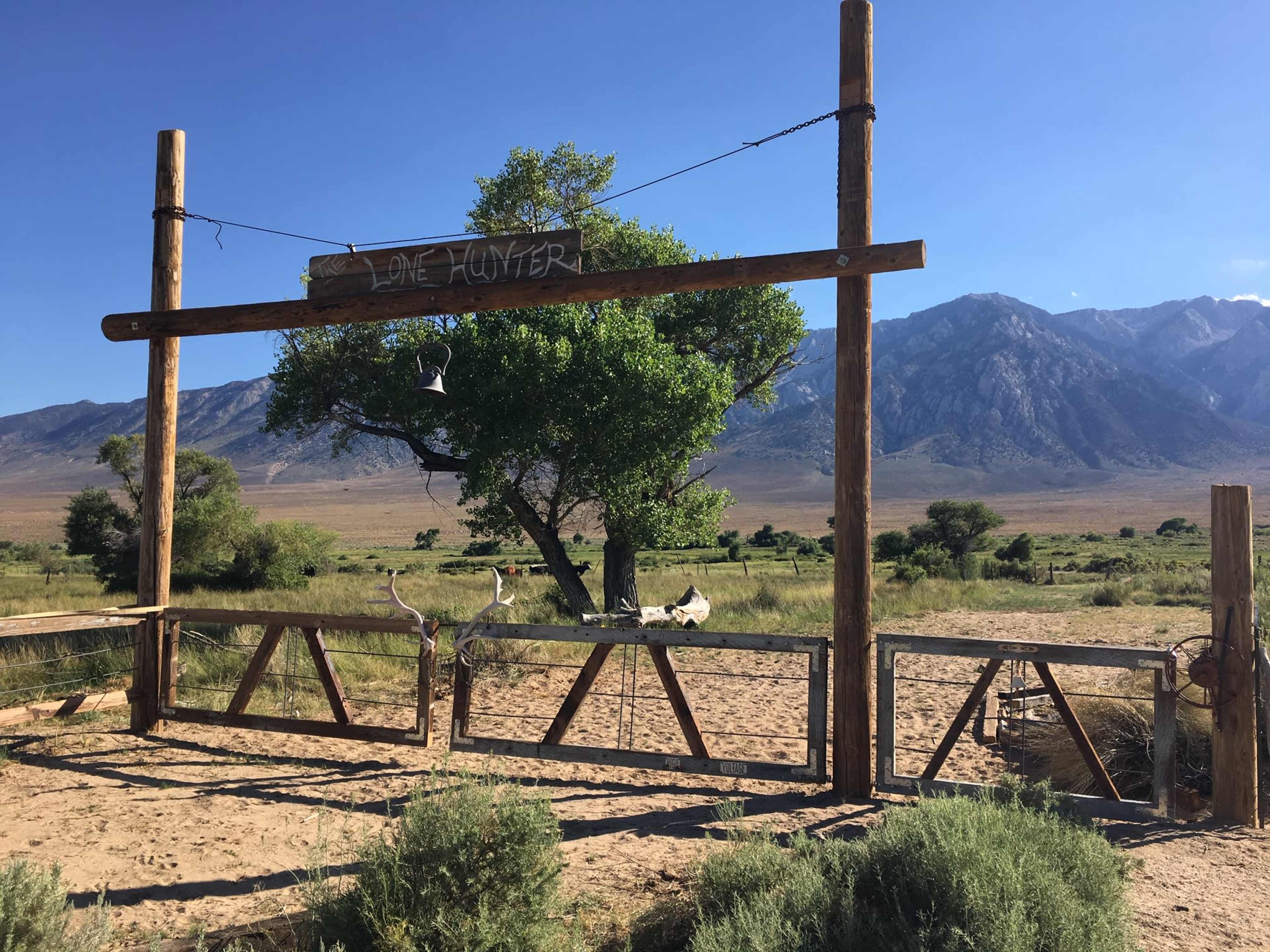 A wooden entrance marked "Love Hunter" stands in front of a mountainous landscape with sparse vegetation.