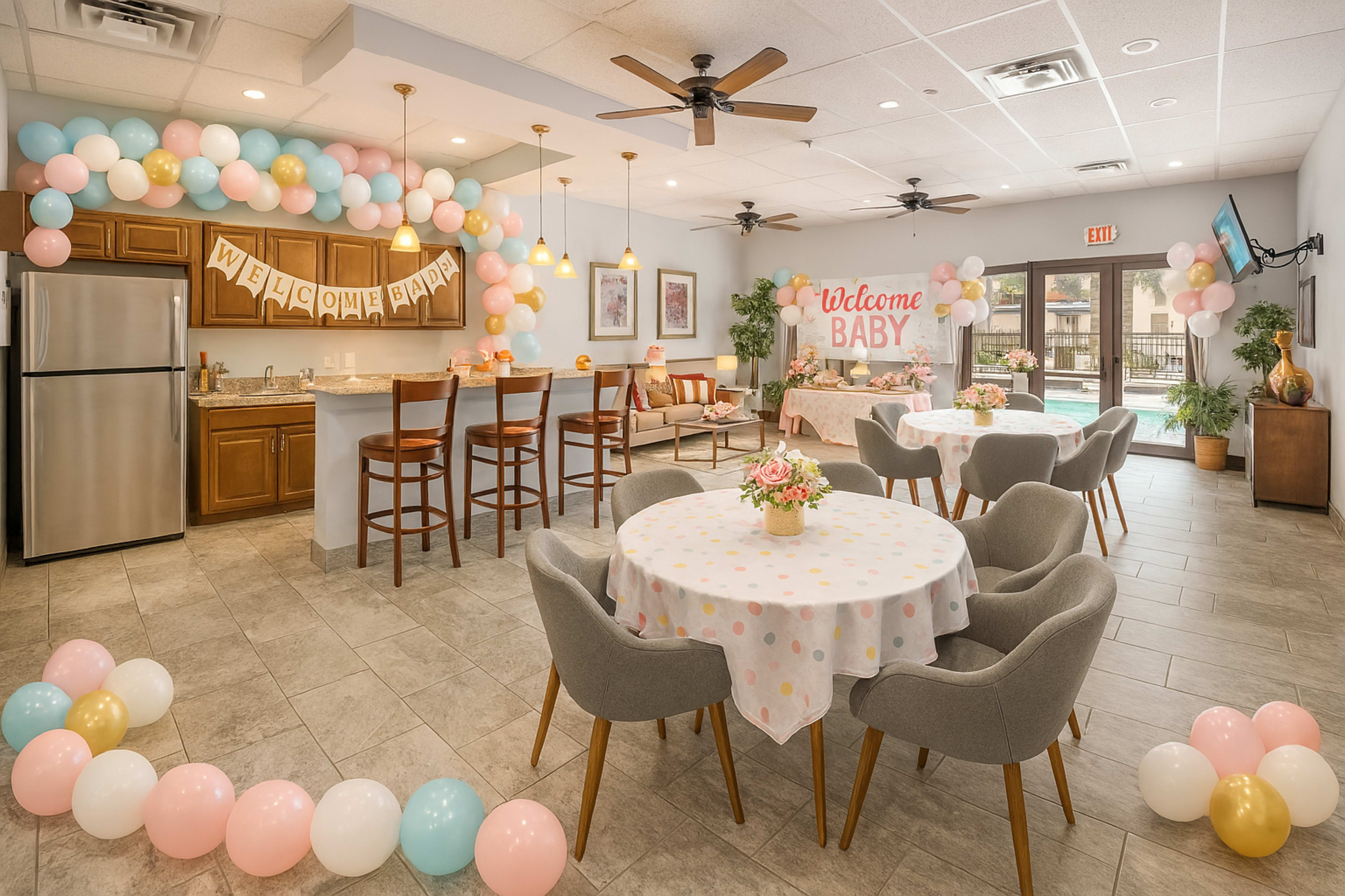 The image shows a decorated event space for a baby shower, featuring tables with polka dot tablecloths, balloons in pastel colors, and a welcoming banner.