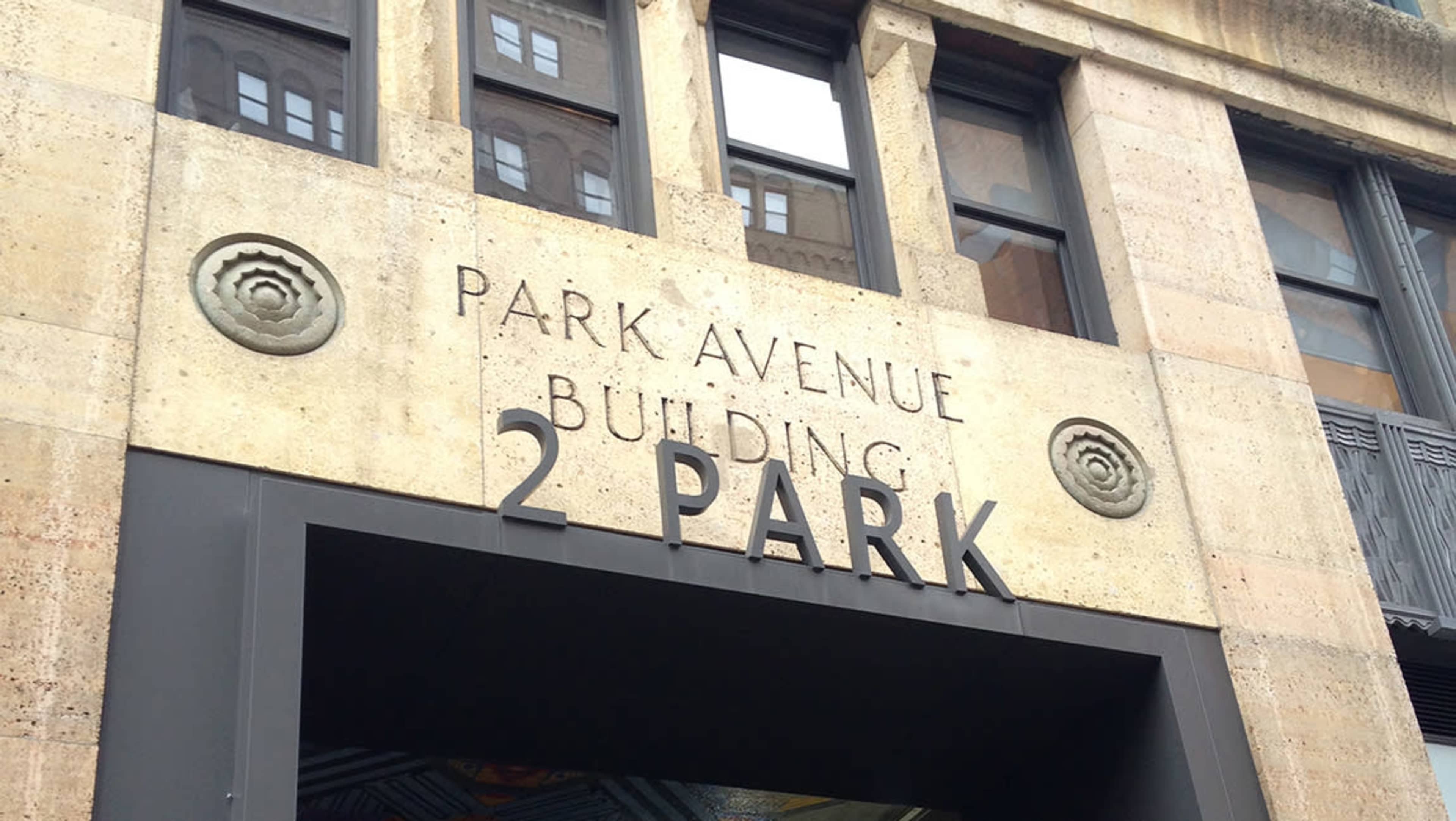 The image shows the entrance of the Park Avenue Building, featuring ornate detailing and the address "2 PARK" prominently displayed.