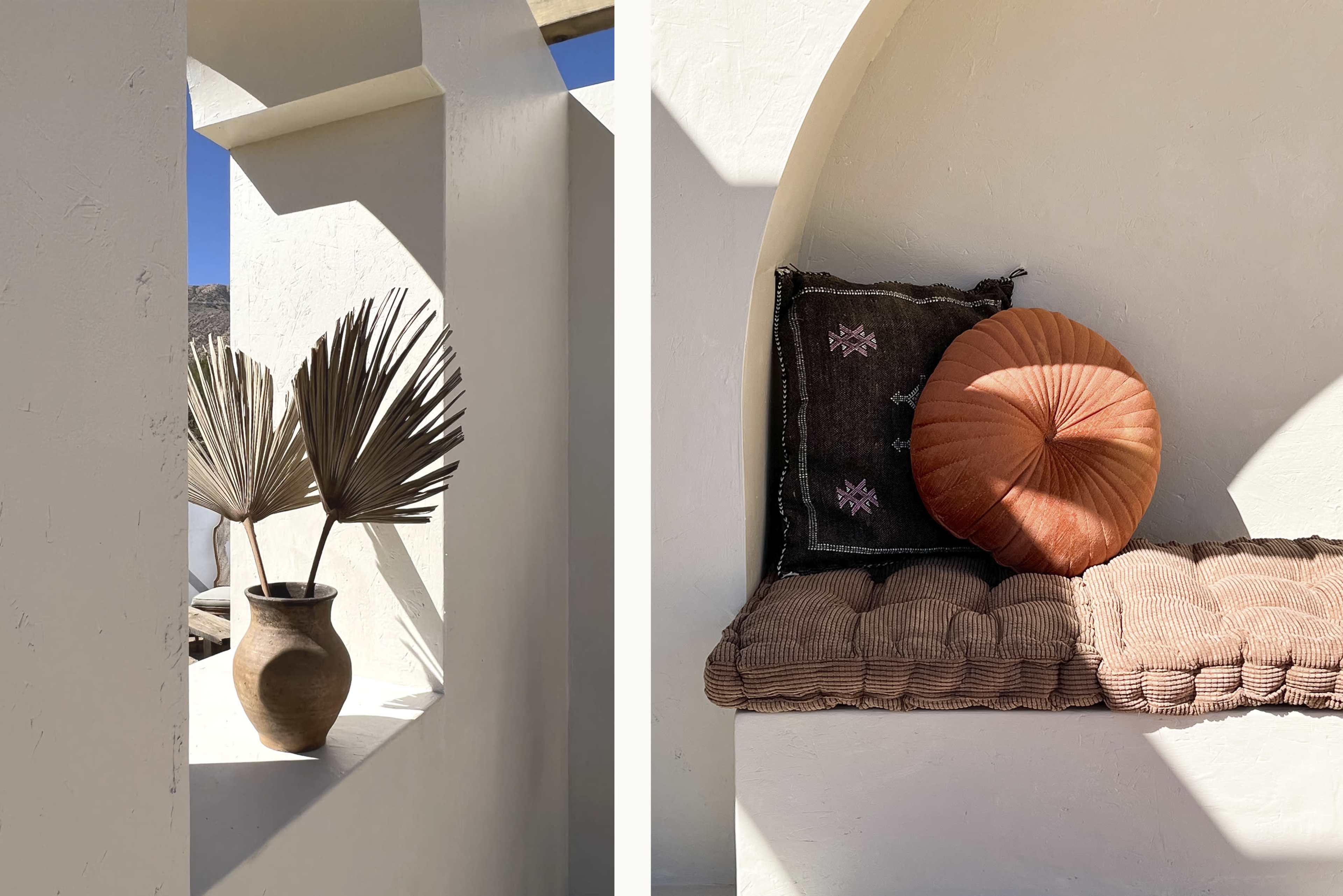 A minimalist interior scene with a decorative vase and dried leaves on one side, and a cozy wall nook with cushions and a round pillow on the other.