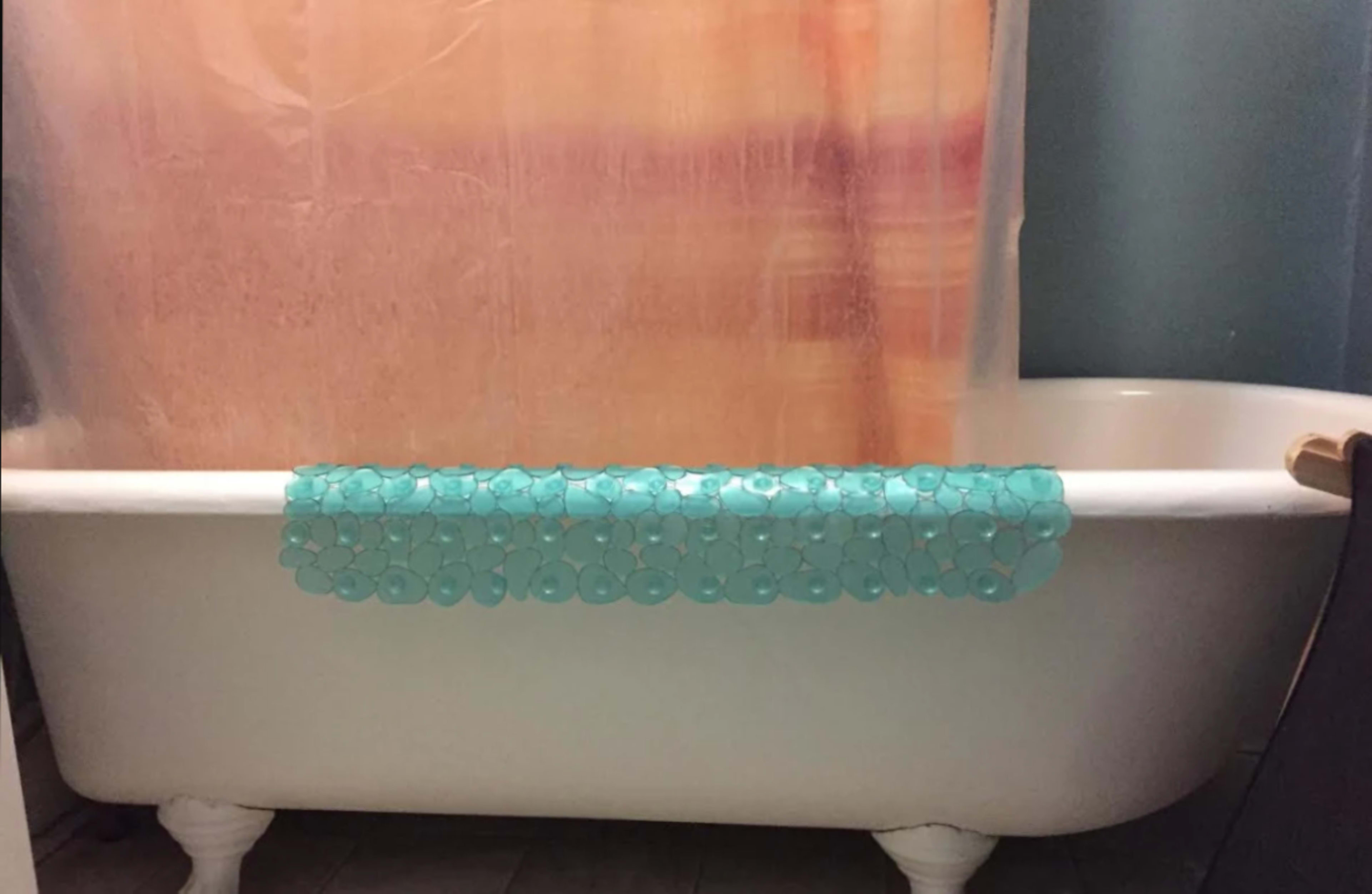 A bathtub with a shower curtain and a row of turquoise discs along the edge.