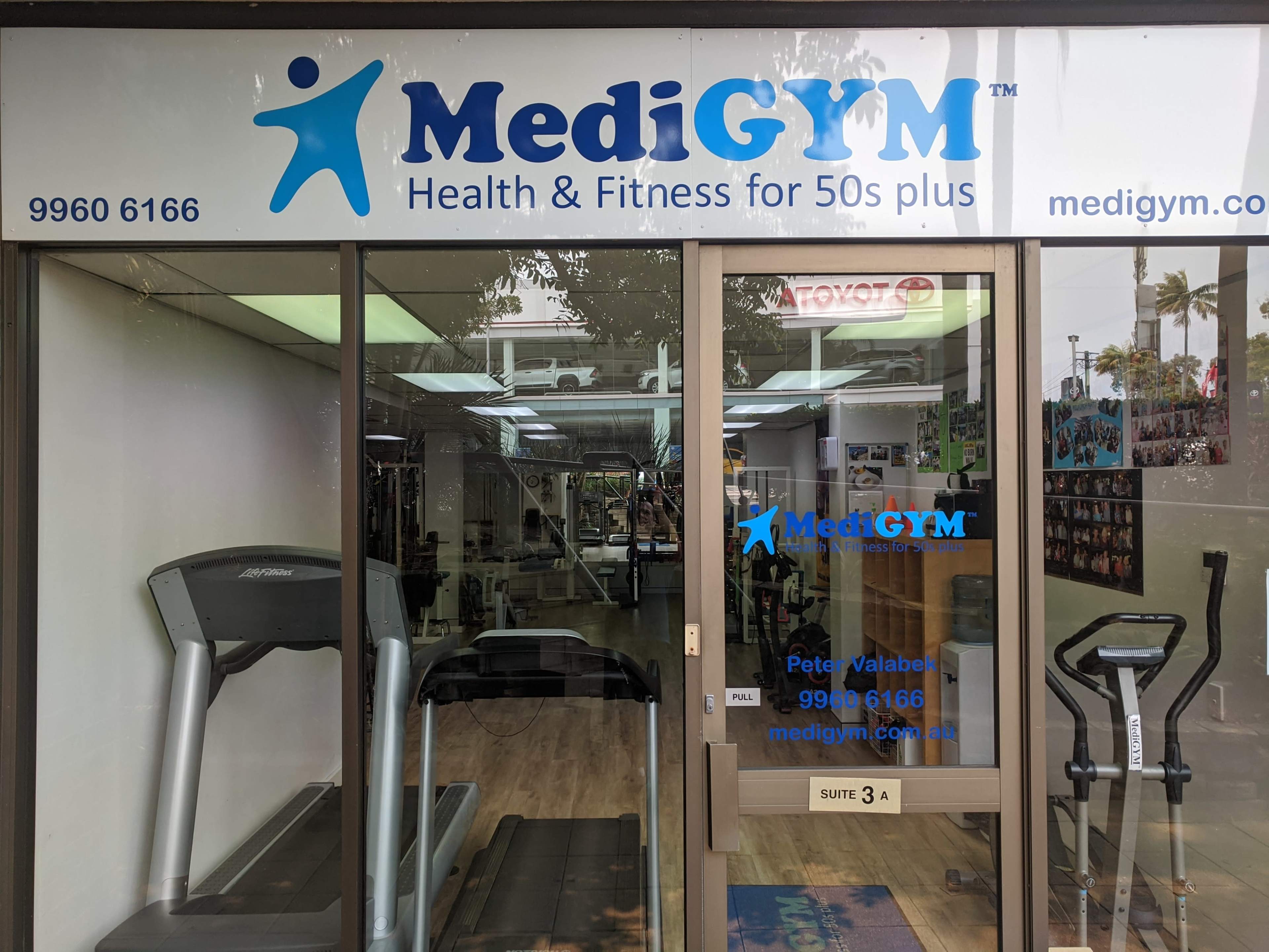 The image shows the entrance of a fitness center named "MediGYM," which specializes in health and fitness for individuals aged 50 and older.