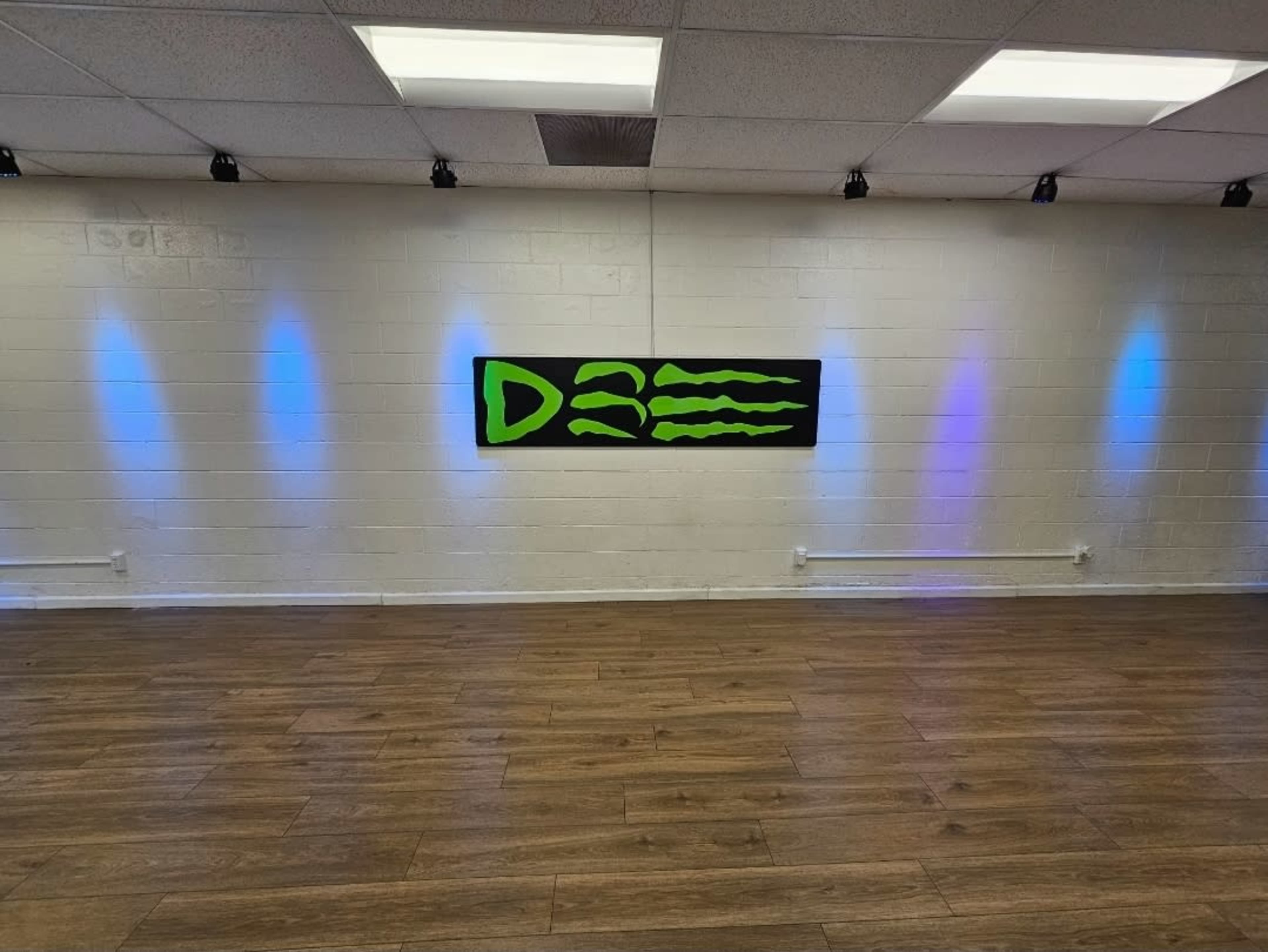 The interior of a room features a black wall art labeled "D3" with green and blue lighting accents on a white brick wall.