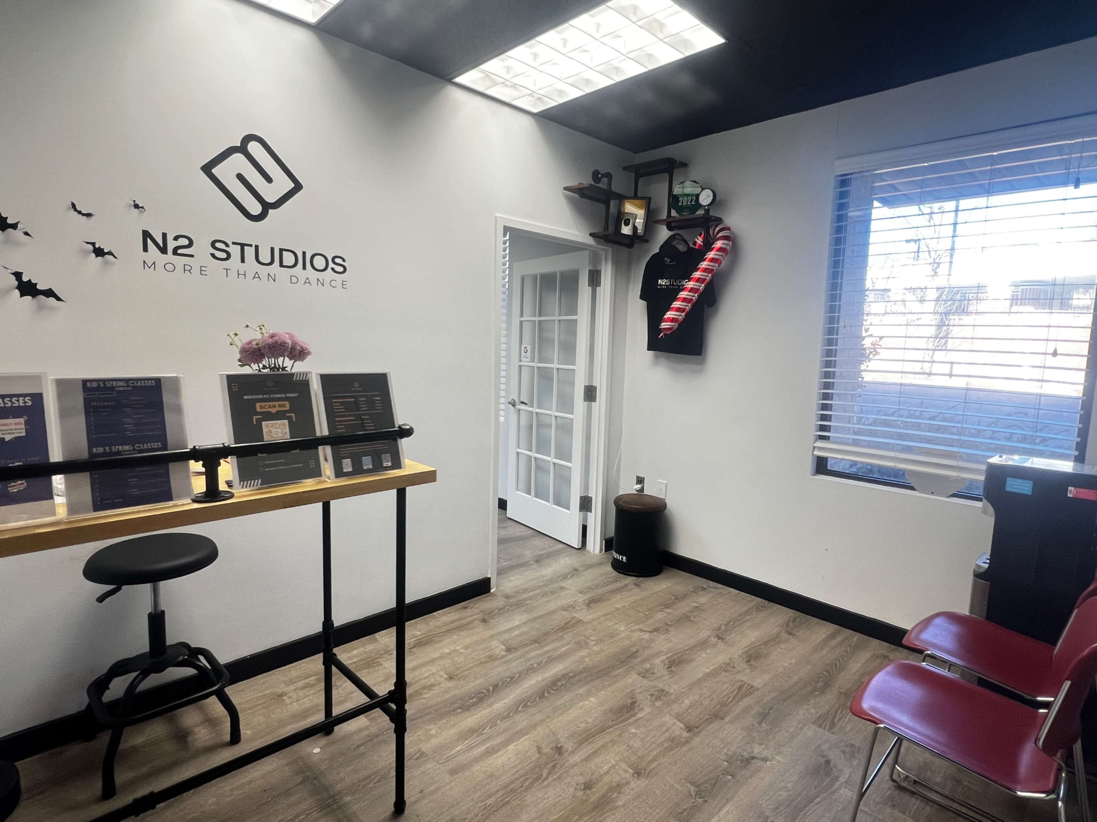 The interior of N2 Studios, featuring a waiting area with a small table, chairs, and decor on the walls.