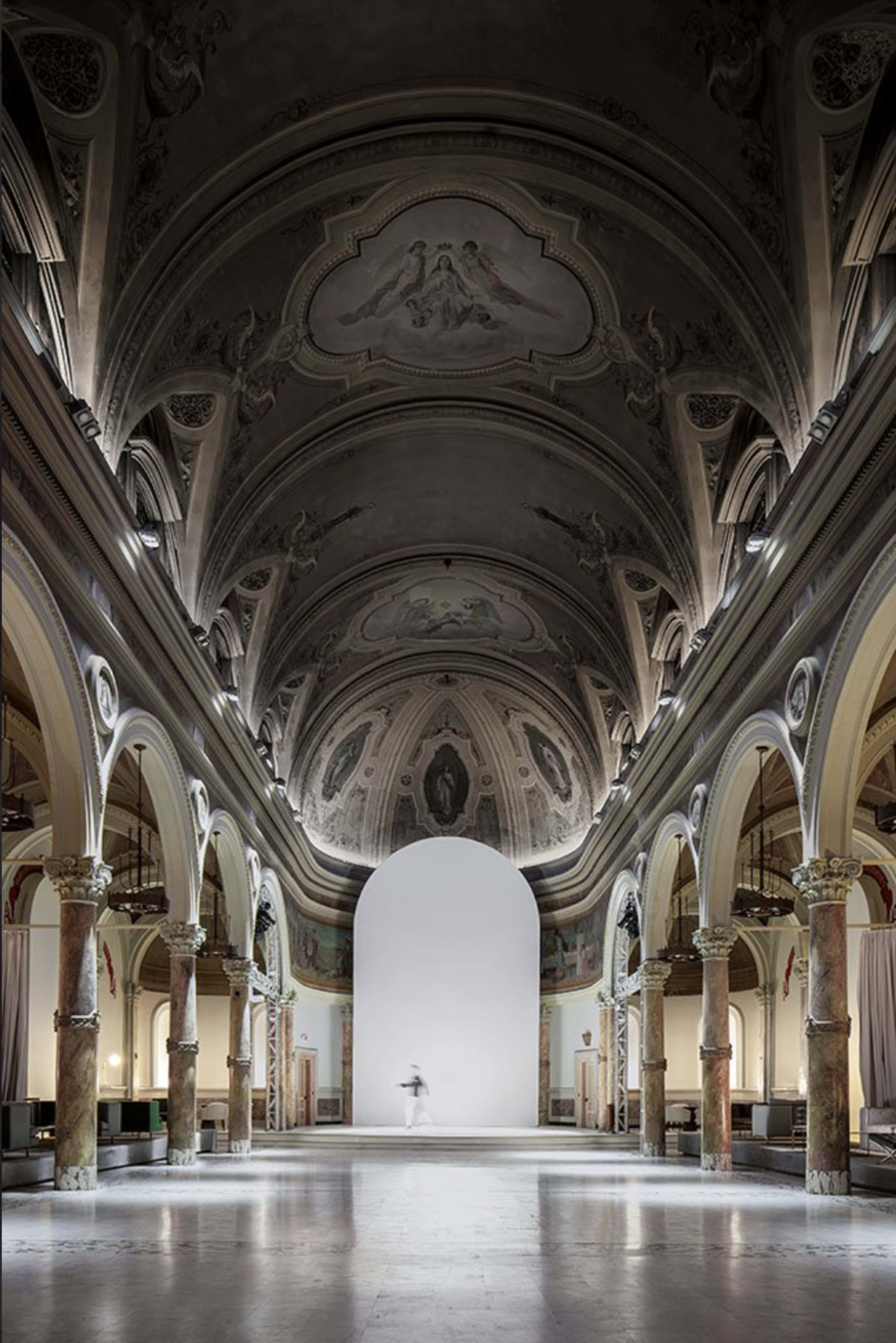 A vast hall with arched ceilings and ornate columns features a central blank space, creating a dramatic perspective.