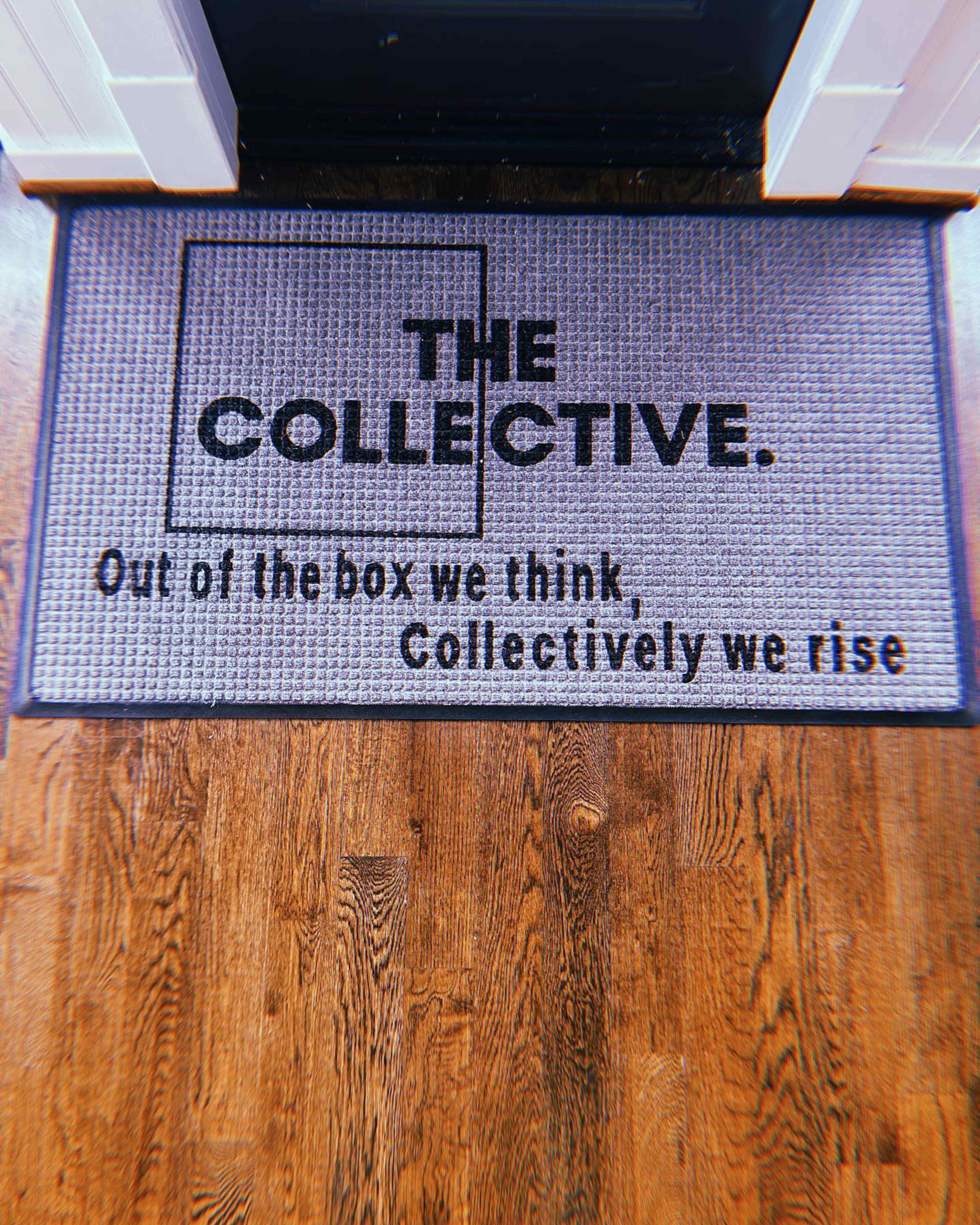 A door mat displays the text "THE COLLECTIVE. Out of the box we think, Collectively we rise" on a textured surface.