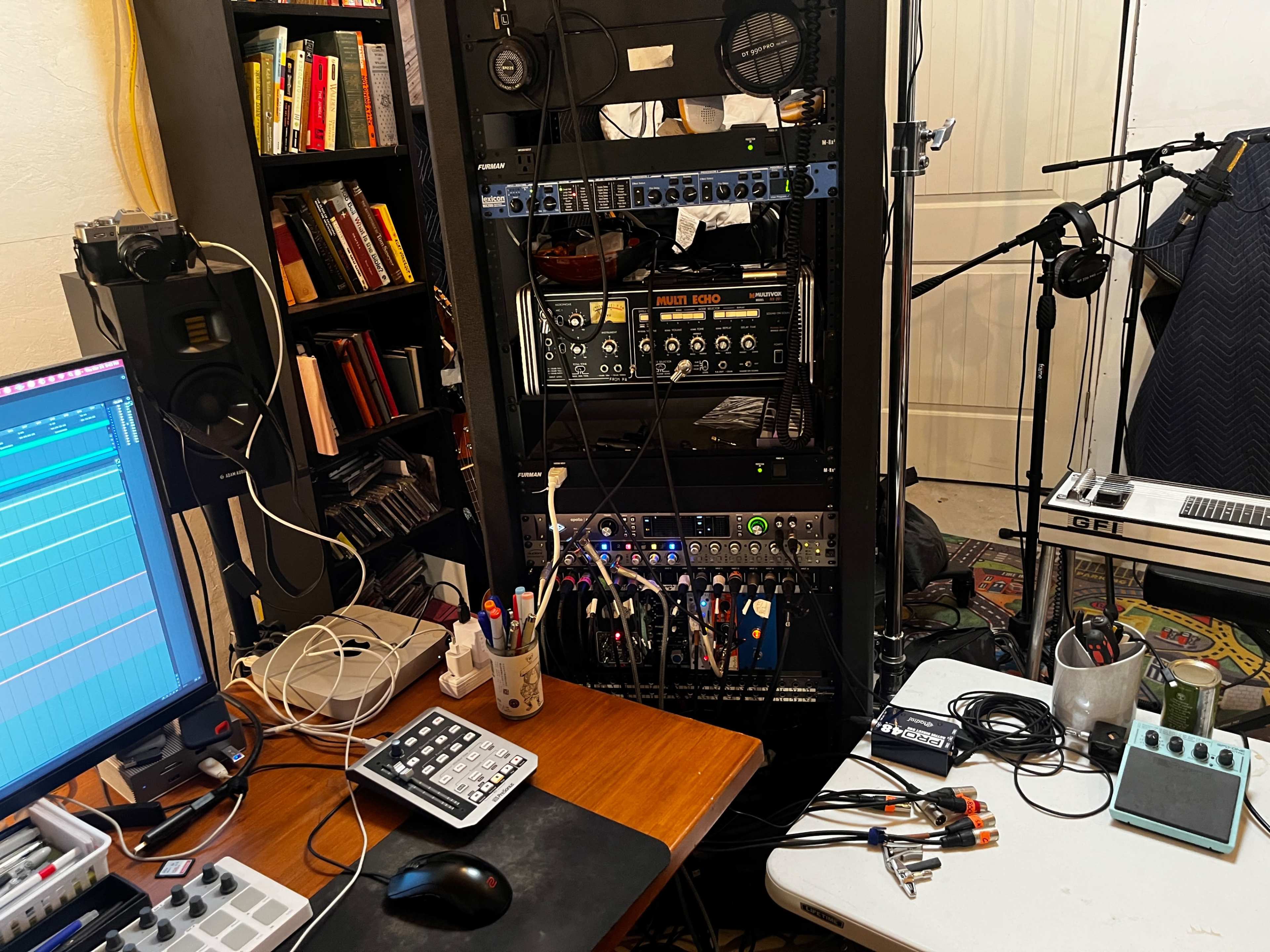 A recording studio setup featuring audio equipment, a computer interface, cables, and a microphone.
