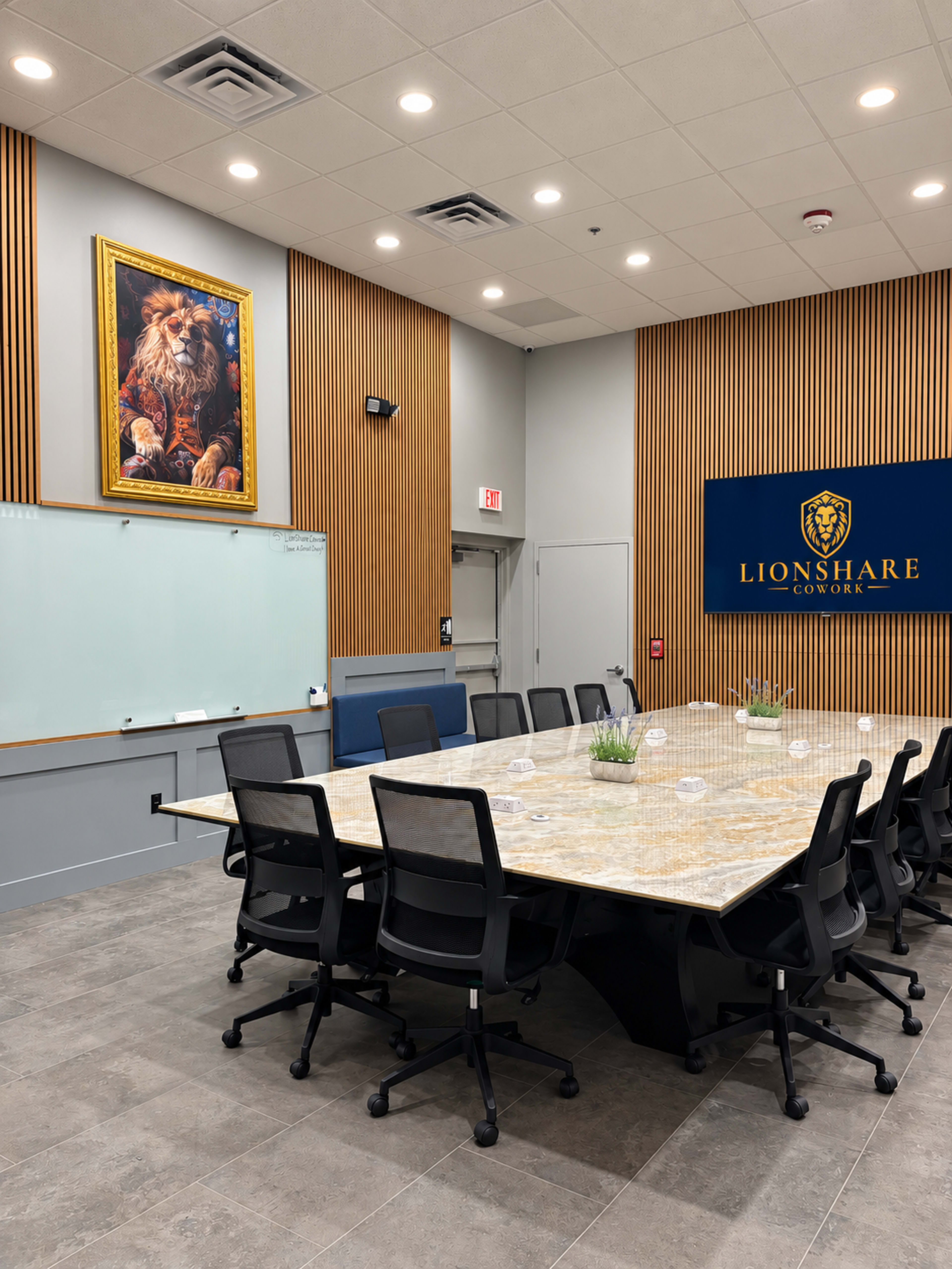 A large conference room features a rectangular table surrounded by black chairs, with a lion painting on the wall and a company logo displayed nearby.