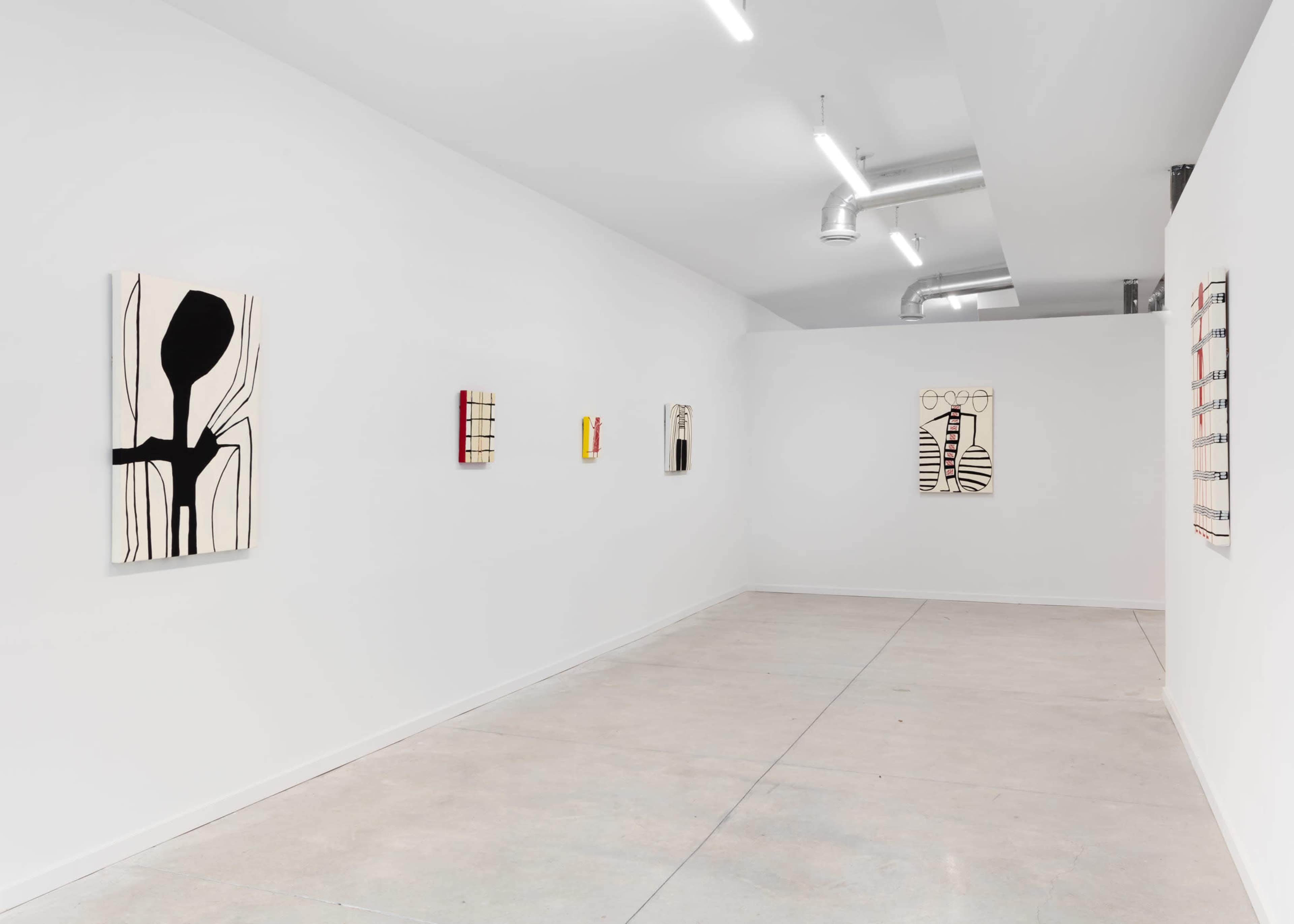 A minimalist art gallery featuring several abstract paintings displayed on white walls with concrete flooring.