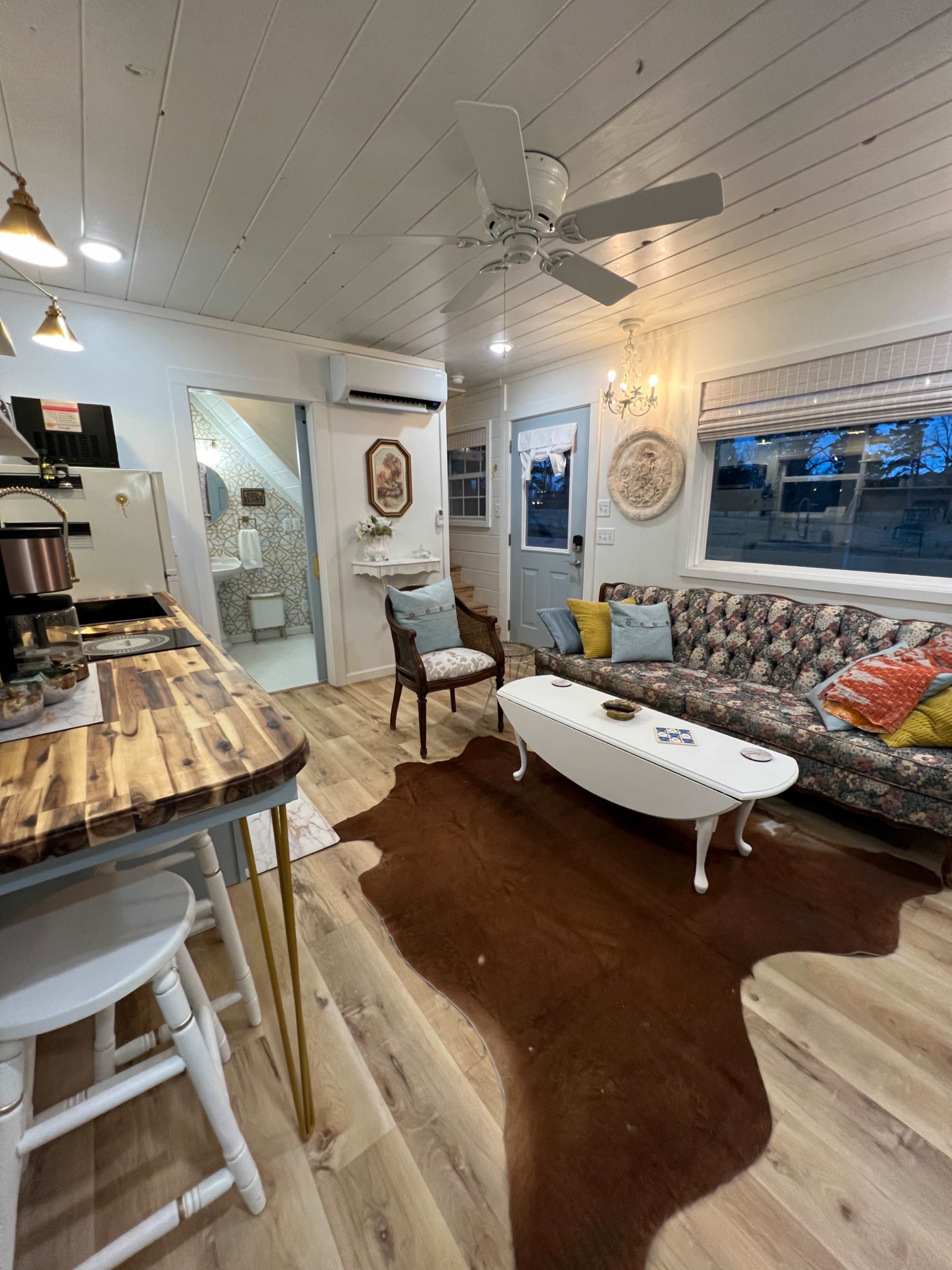 A cozy living area with a patterned sofa, wooden coffee table, and a decorative rug on the floor.