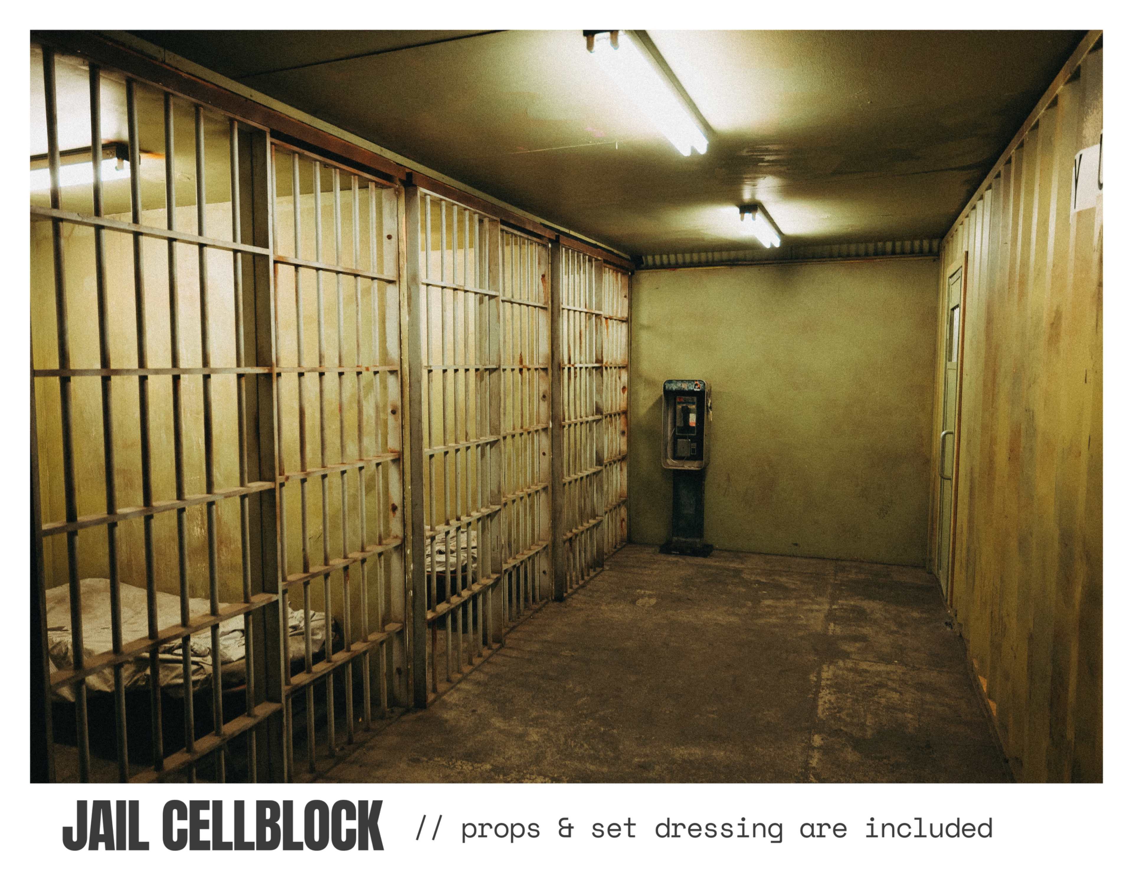 The image shows a jail cellblock with two empty cells, bare mattresses, and a vintage payphone in a dimly lit room.
