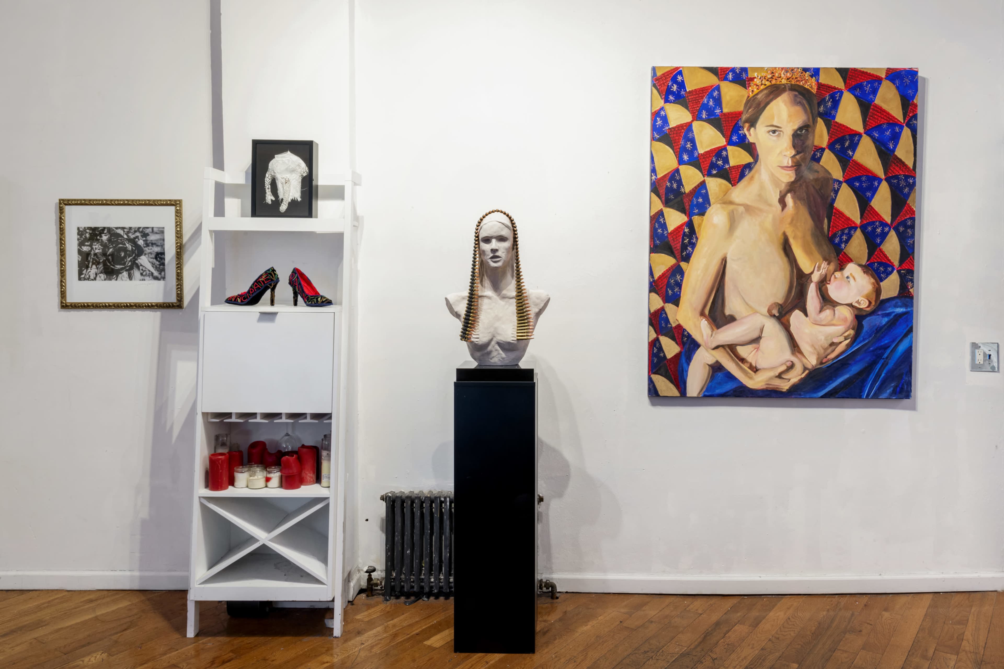 An art gallery featuring a painted portrait and a sculpture displayed alongside photographs and decorative items.