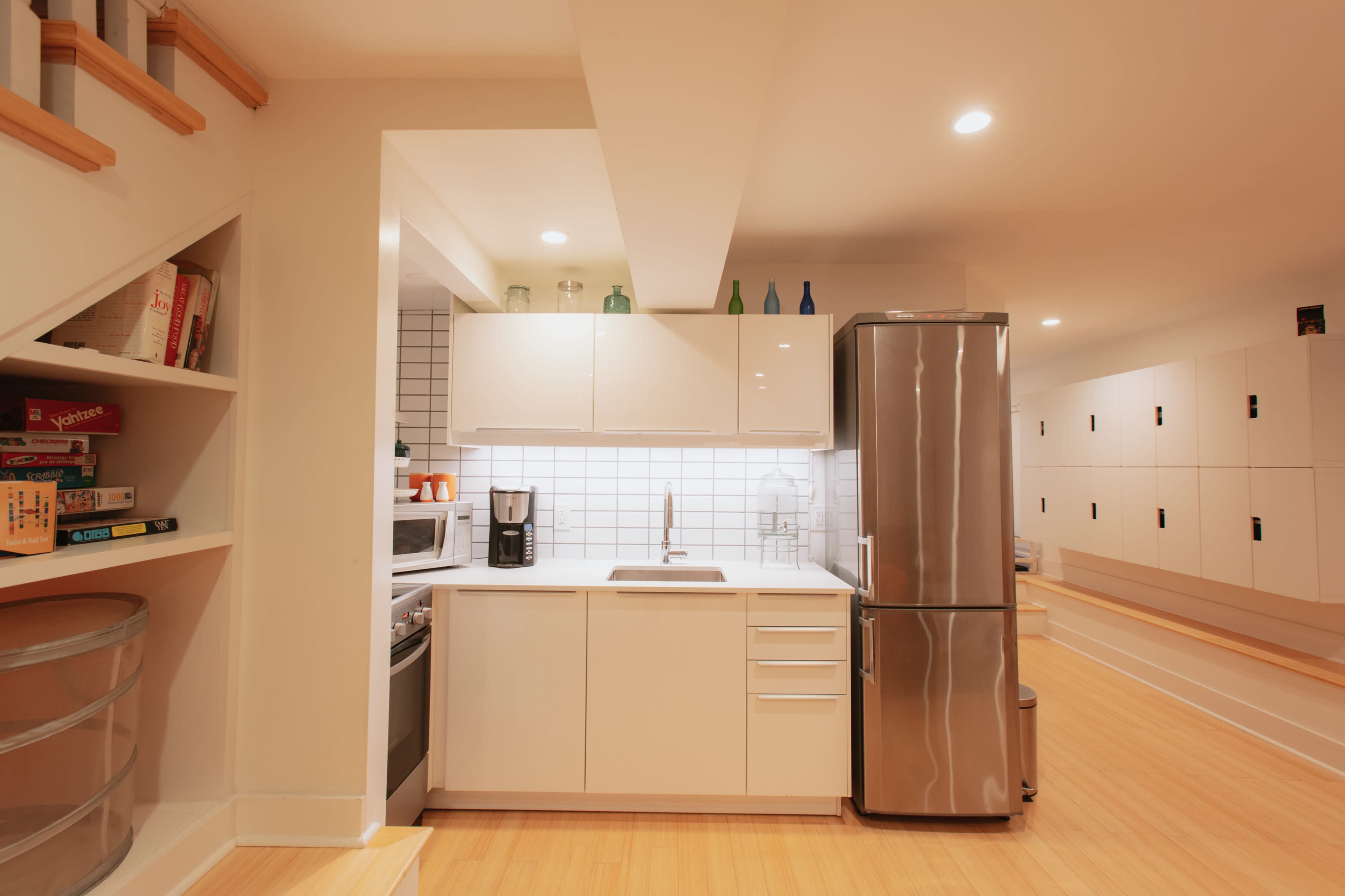 A modern kitchen with white cabinetry, a stainless steel refrigerator, and a countertop with a sink.