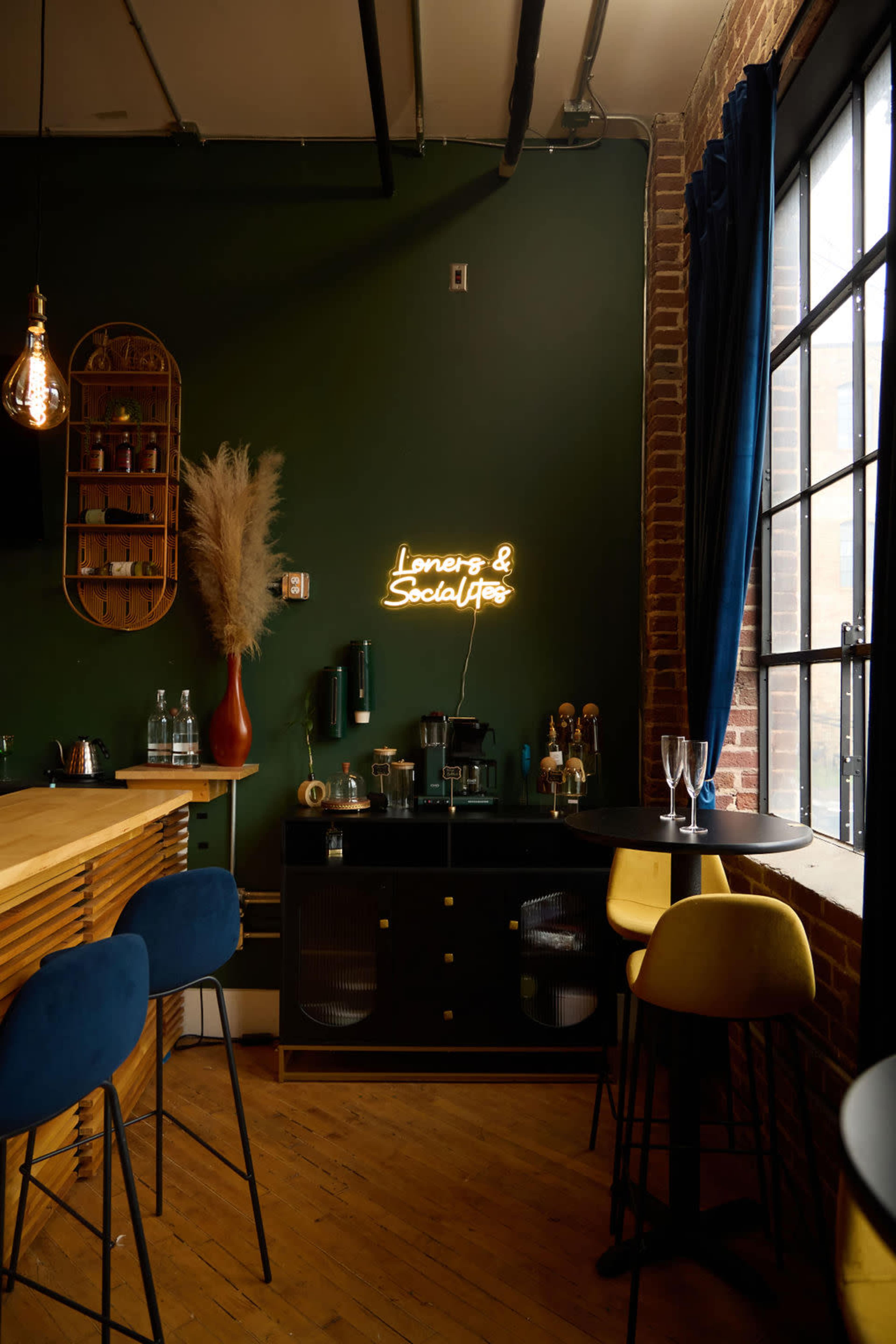 A cozy bar area features a dark green wall, wooden counter, and a neon sign that reads "Lovers & Soulmates."