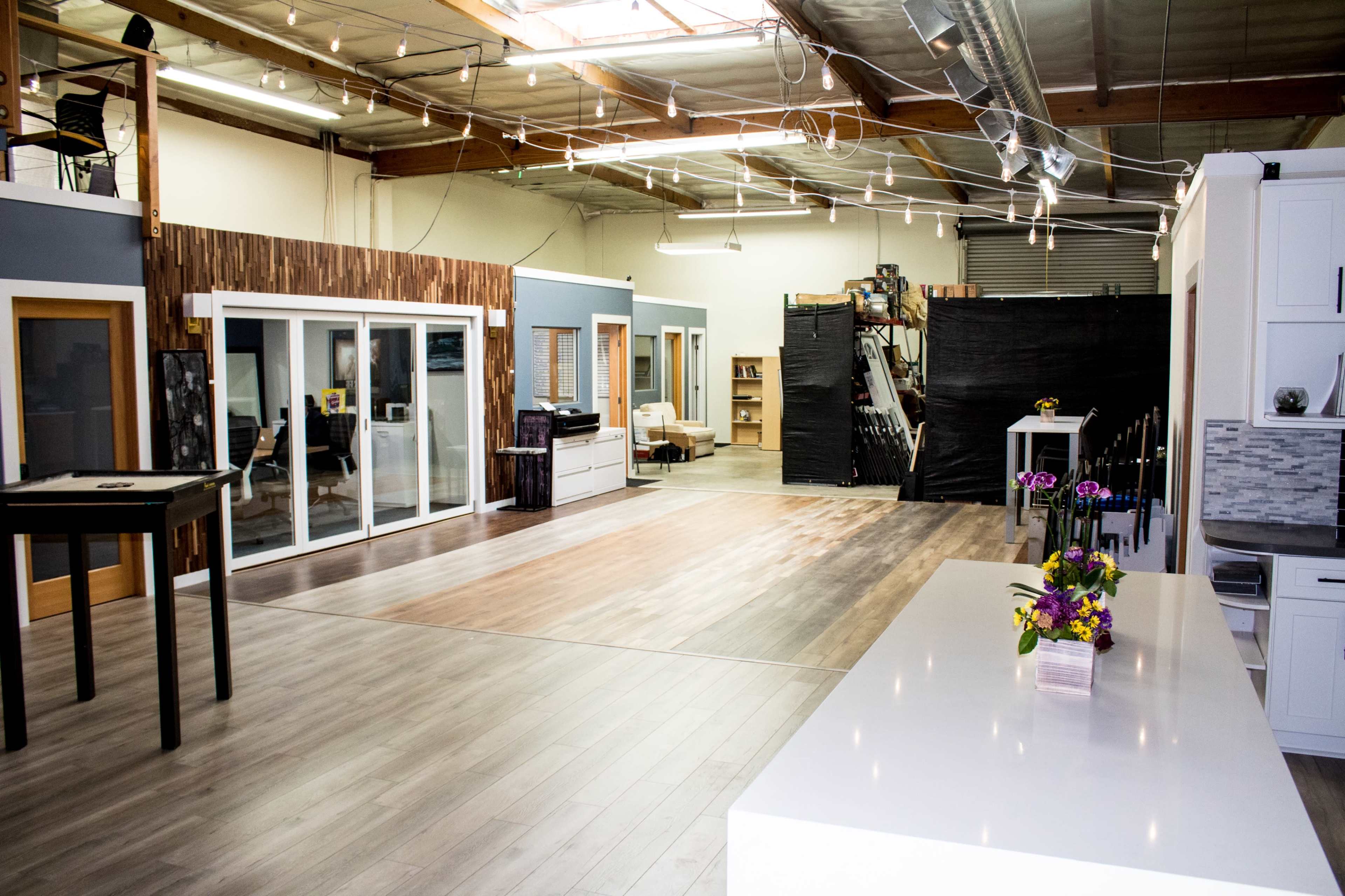 A spacious, well-lit interior of a modern workshop or studio with wooden accents and an open layout.