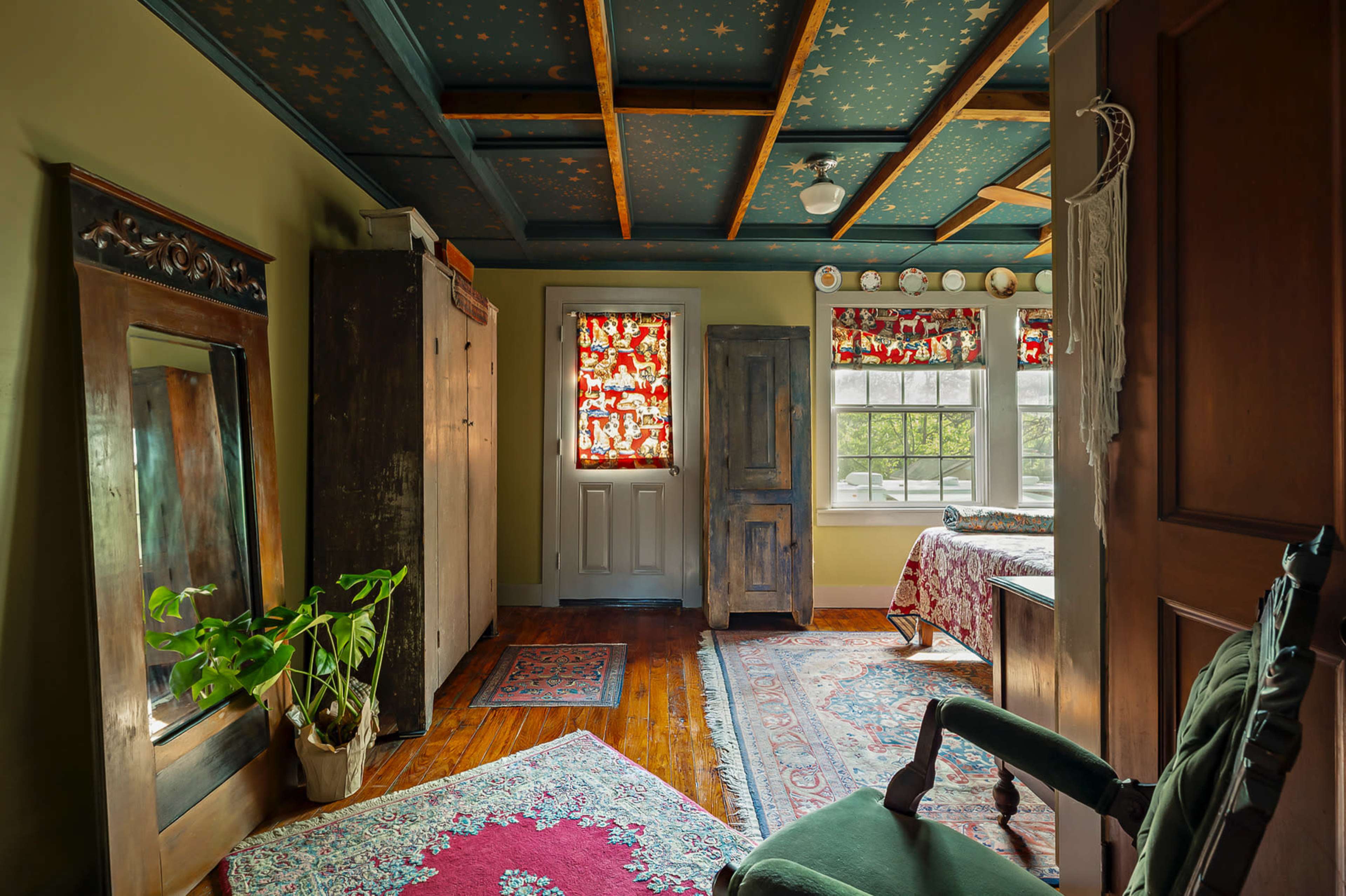 The image depicts a cozy bedroom with a starry ceiling, a wooden bed, an ornate mirror, an armoire, and windows adorned with patterned curtains.