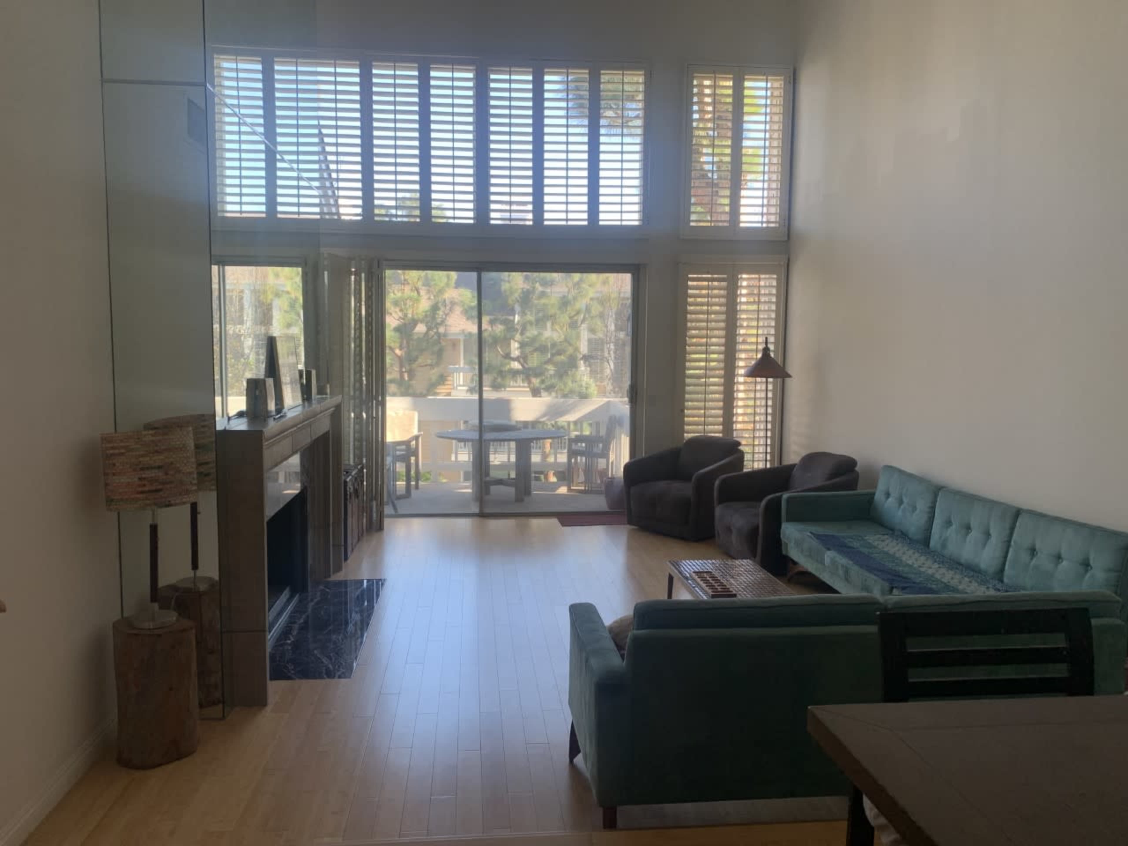 A spacious living room with large windows, a fireplace, and a view of an outdoor area.