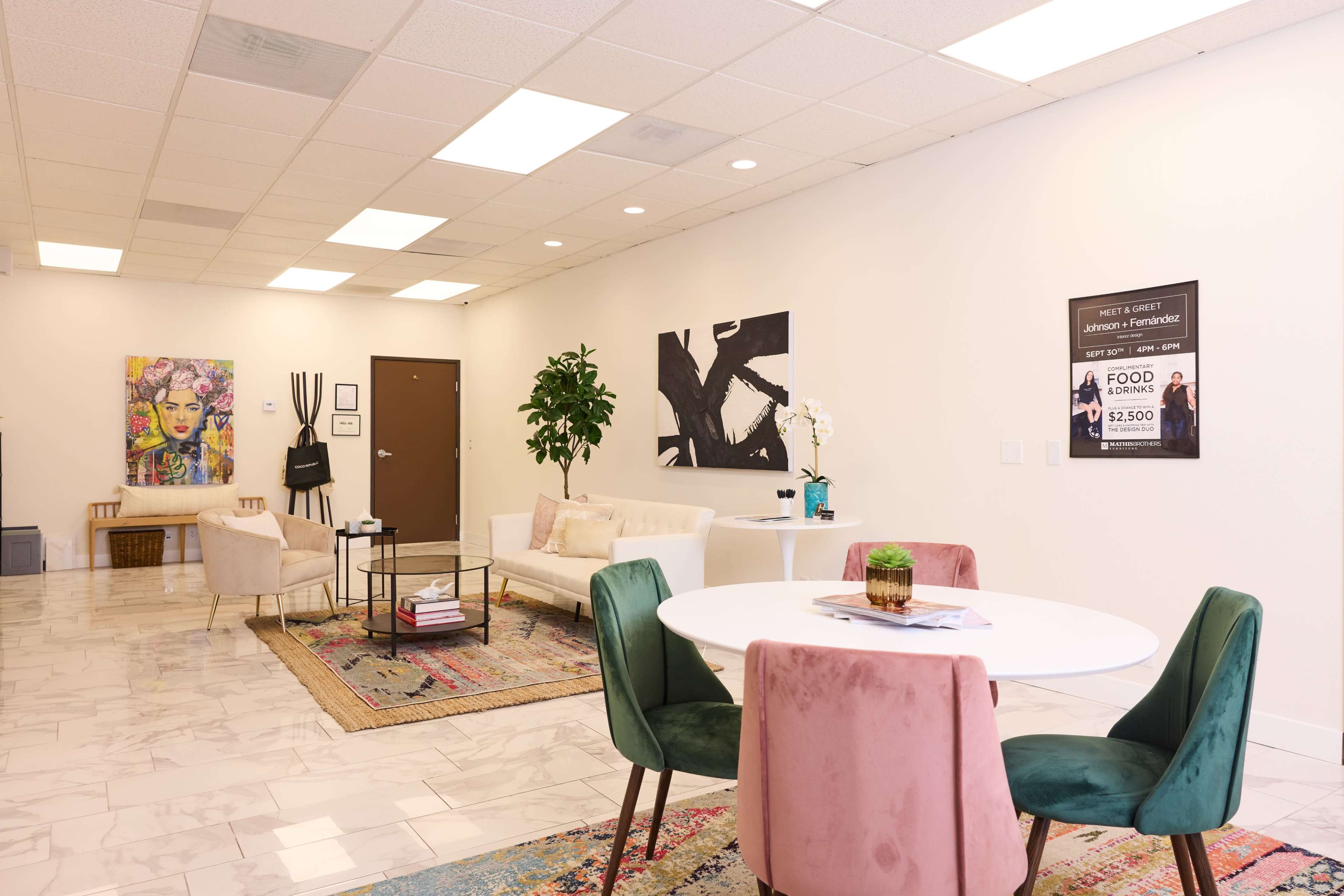 A spacious, modern interior with a seating area, a dining table, and artwork on the walls, complemented by a plant and decorative elements.