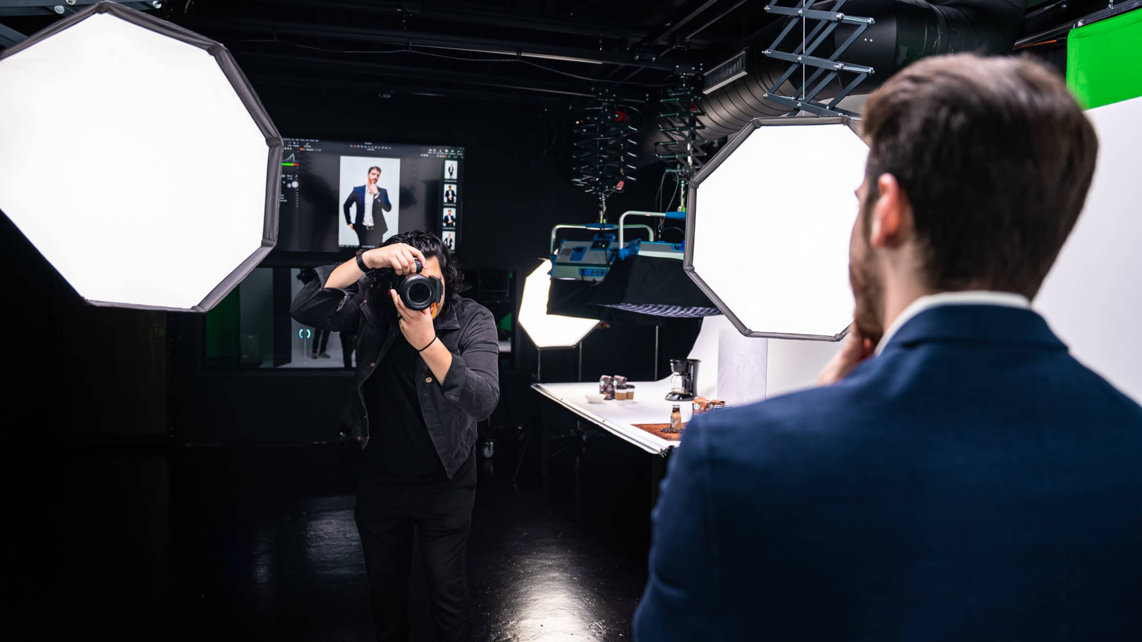A photographer captures a subject in a studio setting with professional lighting and equipment.