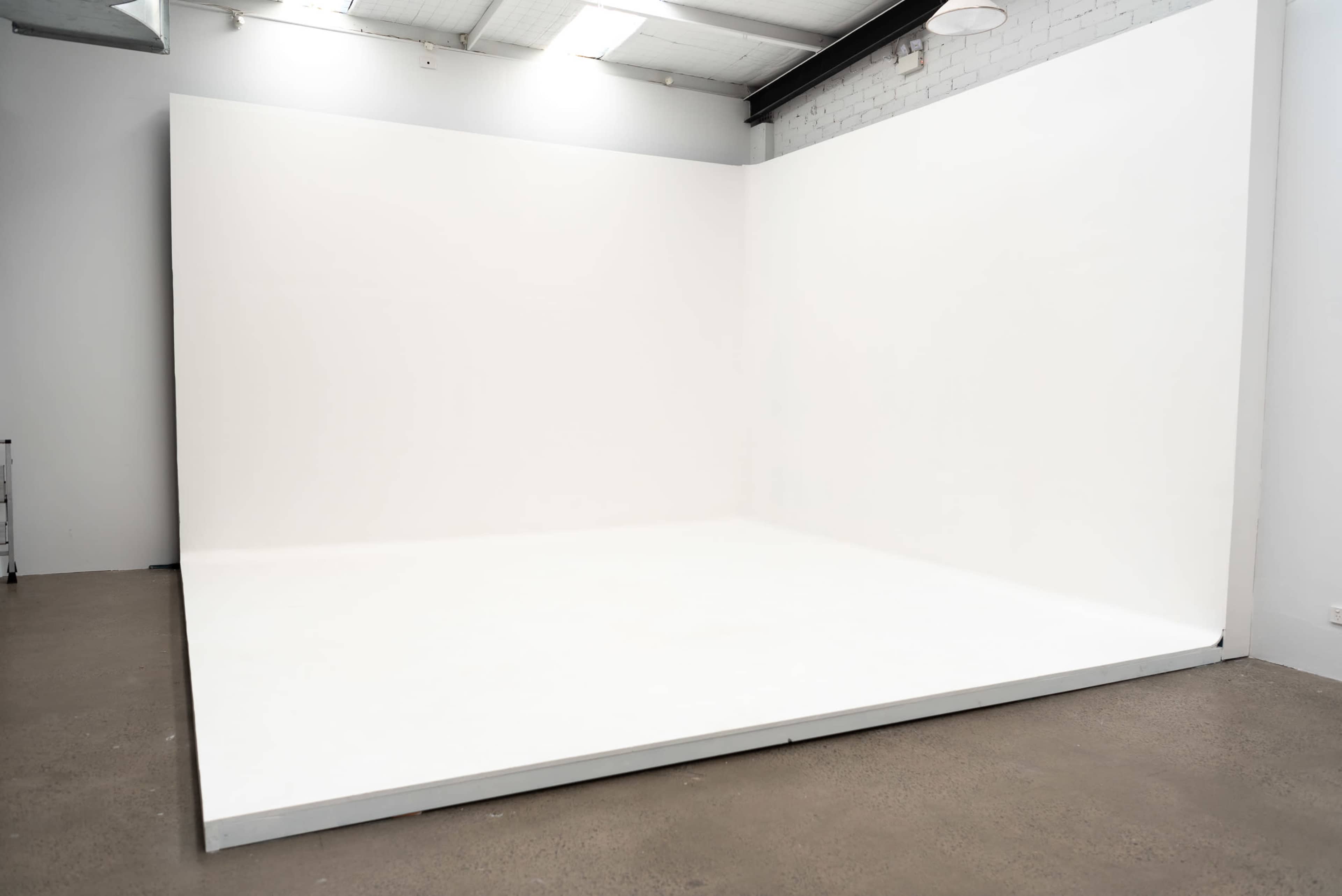 A large empty white room with a smooth floor and an uncrowded backdrop.
