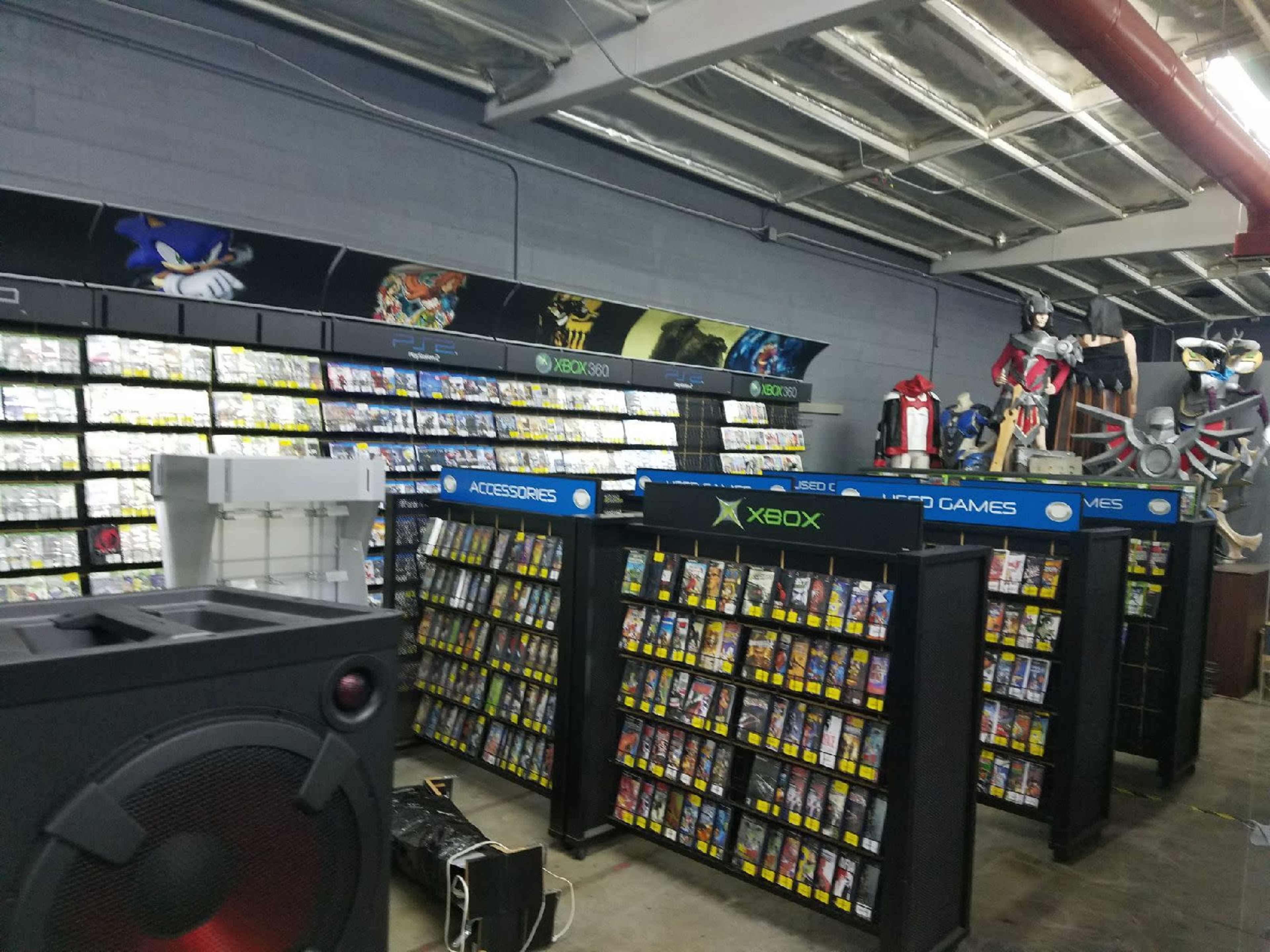 A retail store aisle filled with shelves of video games and consoles, featuring organized displays and gaming accessories.