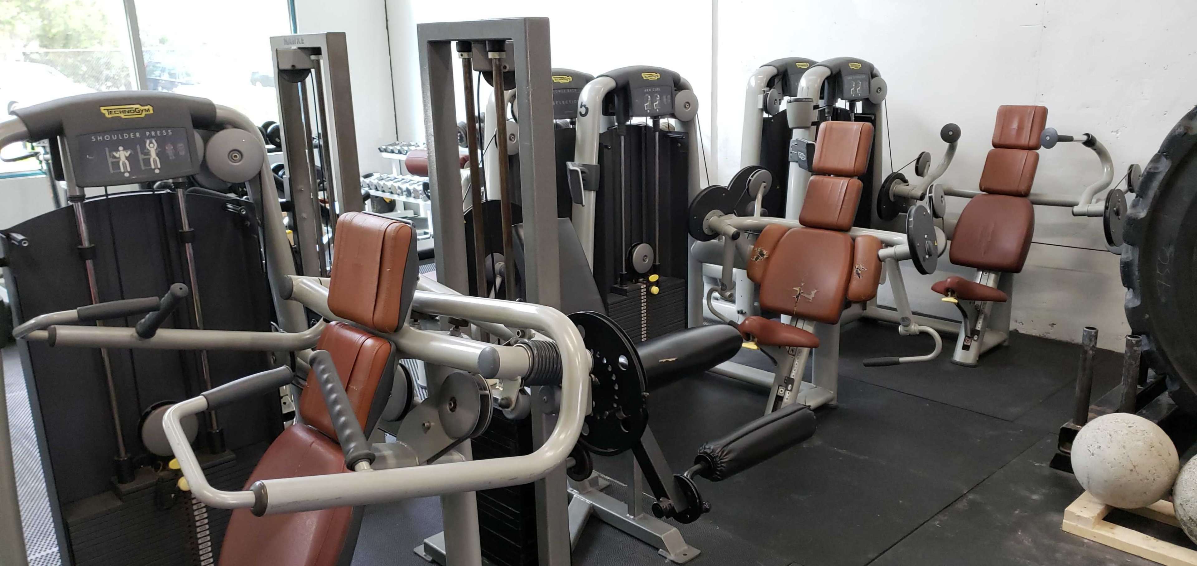 Several pieces of gym equipment arranged neatly in a fitness facility.