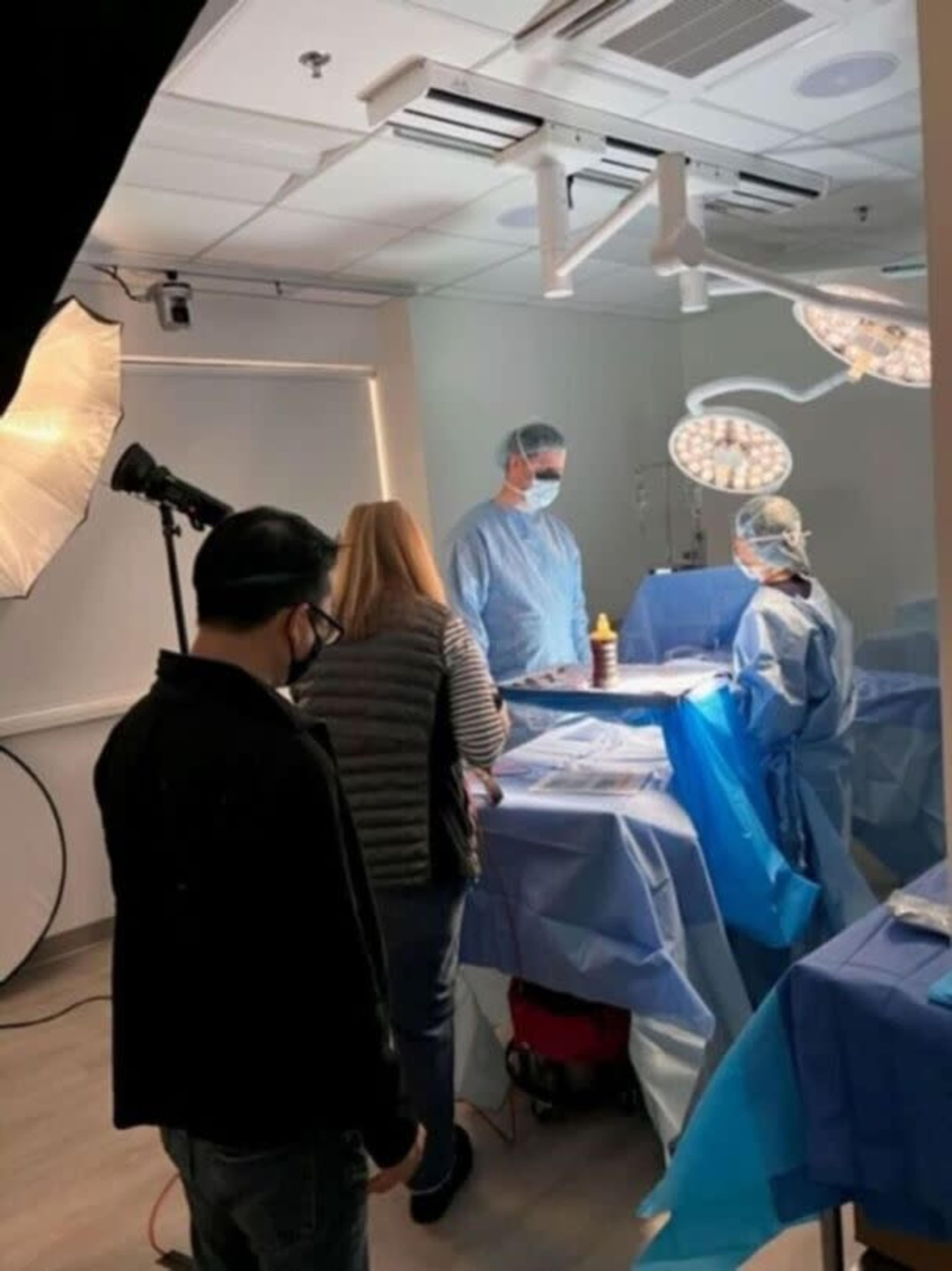 A medical team prepares for a surgical procedure in a well-lit operating room.