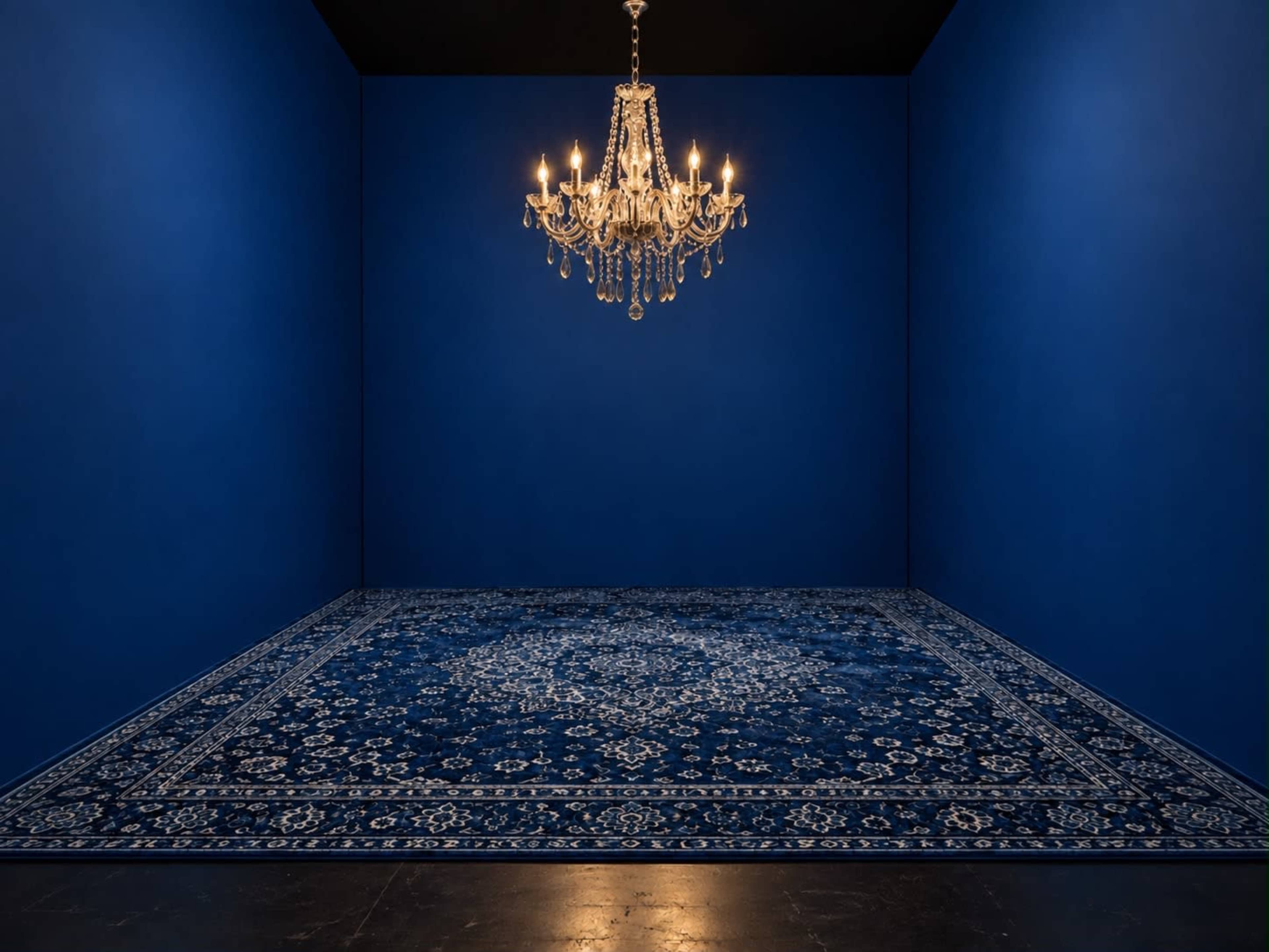 A crystal chandelier hangs from the ceiling in a room with dark blue walls and a matching patterned carpet.
