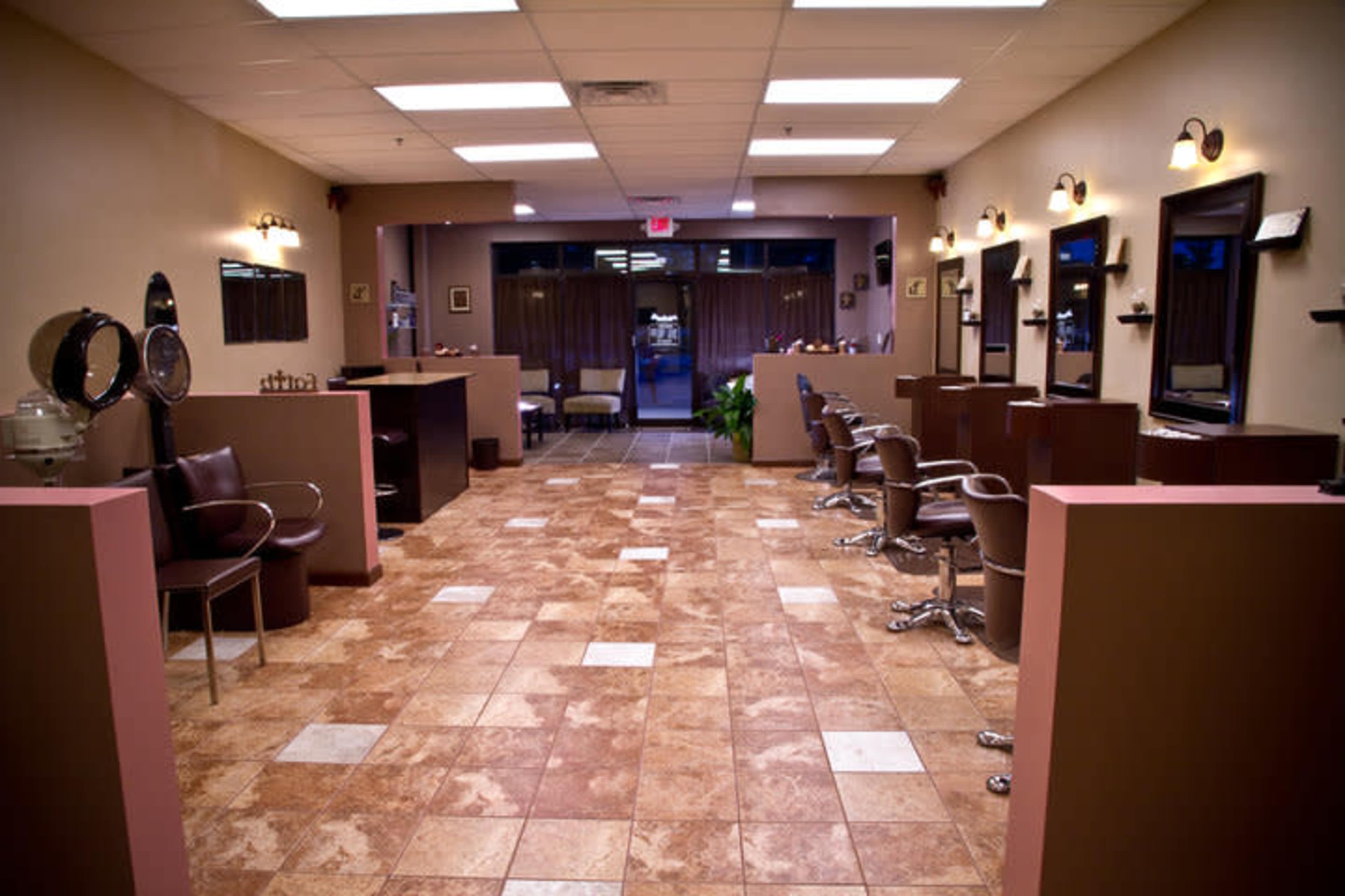 The image shows a spacious hair salon with several styling chairs, mirrors, and a tiled floor.